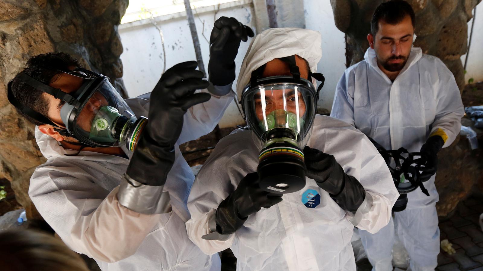 Three Syrian medical staff wear gas masks in a chemical weapons attack training.