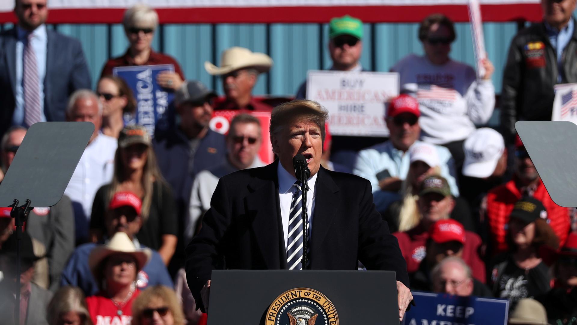 US President Donald Trump addresses the audience at the podium at a rally.