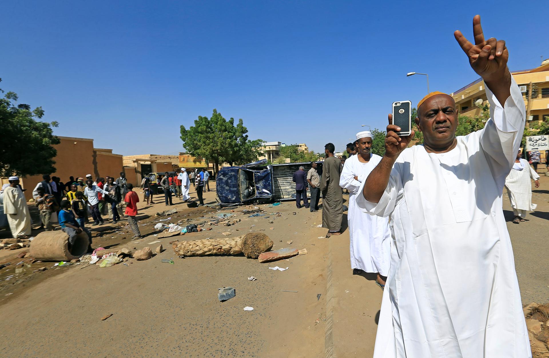 A Sudanese man makes a peace sign with his hands