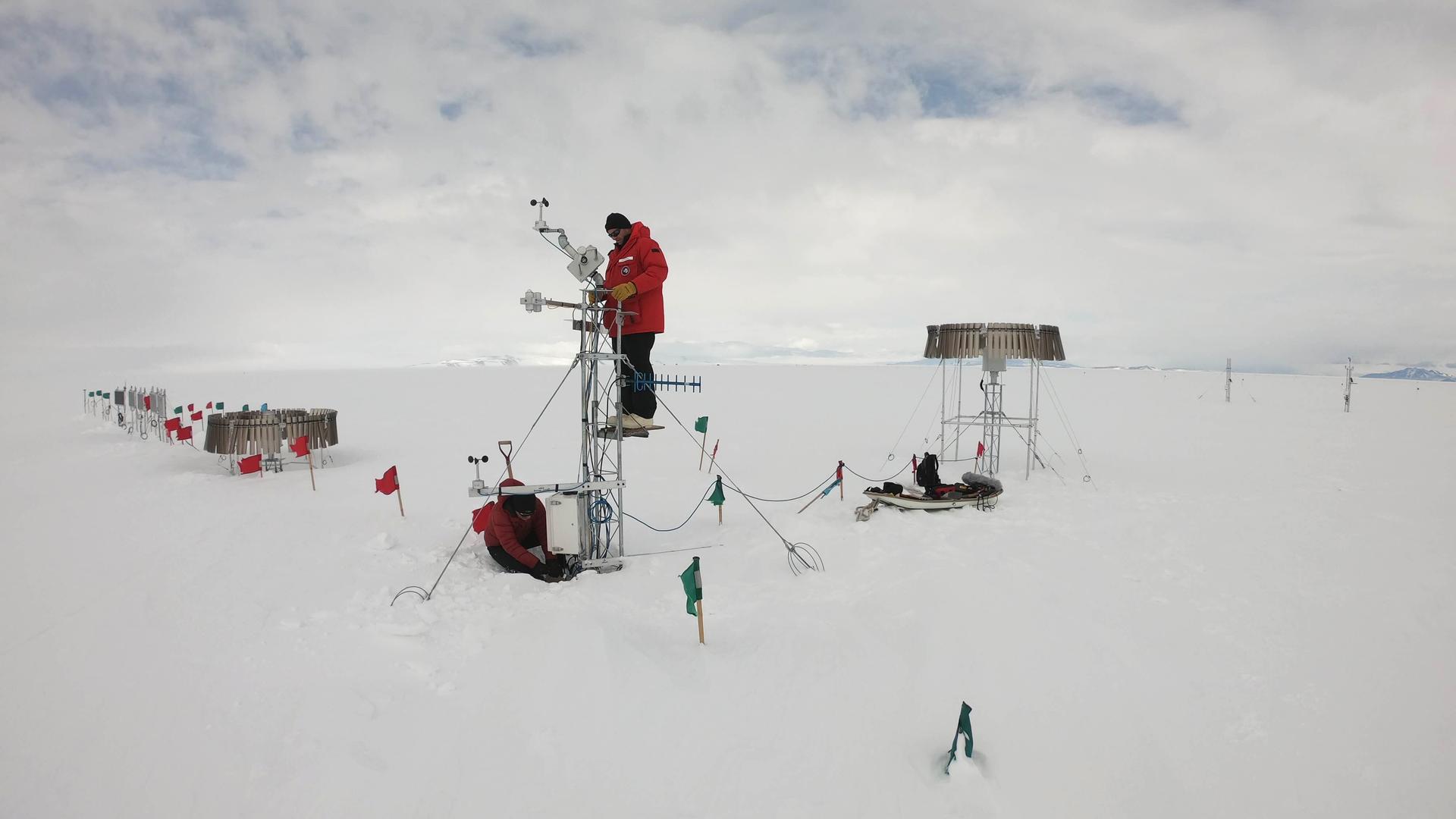 Researchers Scott Landolt and Mark Seefeldt set up an automatic snowfall measuring system in Antarctica.
