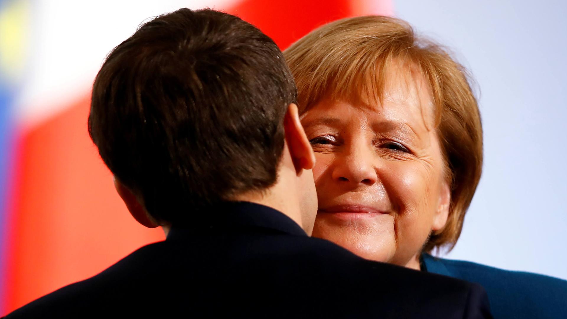 Macron hugs Merkel.