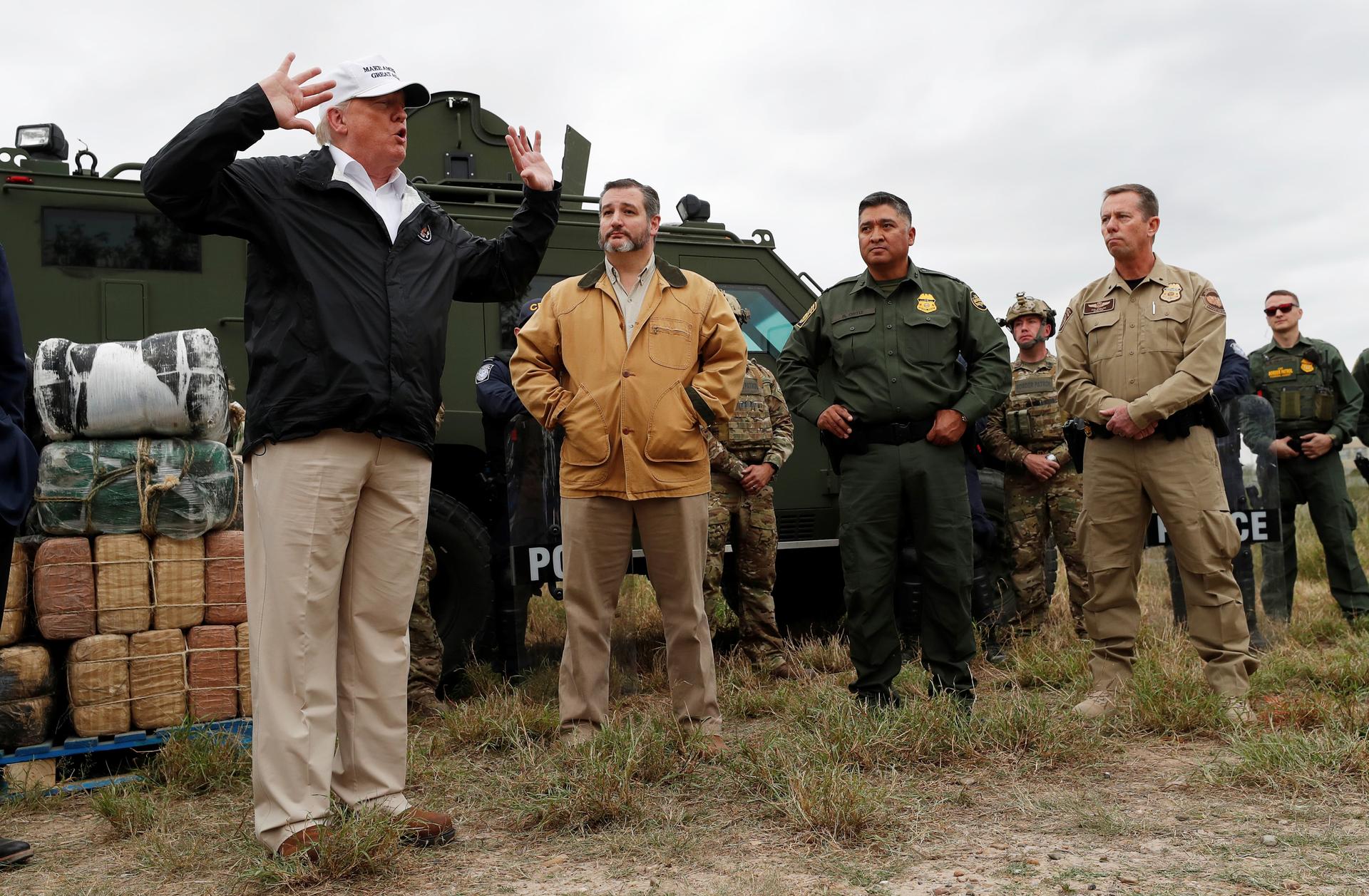 President Donald Trump speaks to reporters as he stands in front of a helicopter, next to Ted Cruz