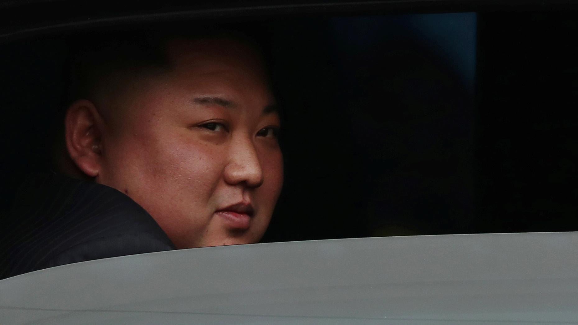 North Korea's leader Kim Jong-un's face behind a halfway rolled down window