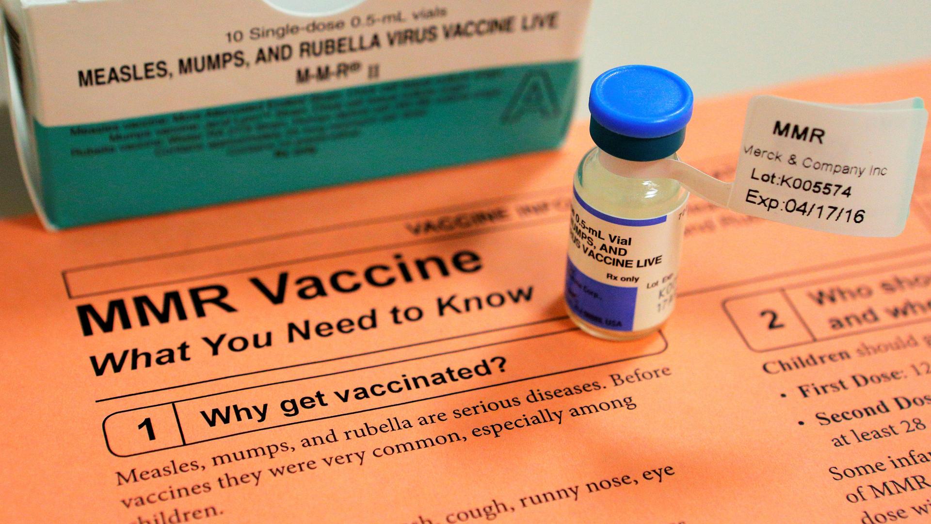 a vial of measles, mumps and rubella vaccine and an information sheet