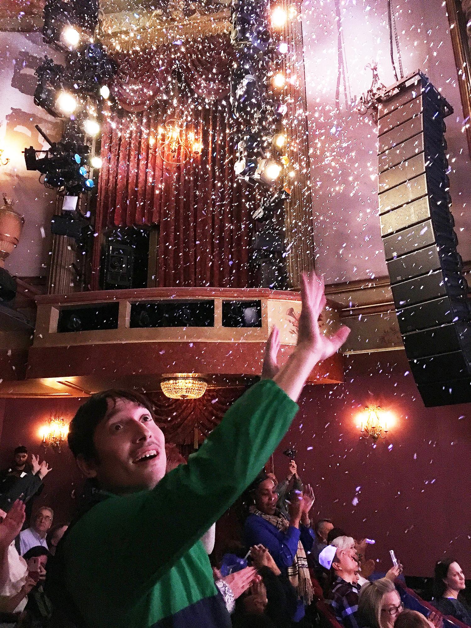 An audience member reaches for the confetti at the close of the show.