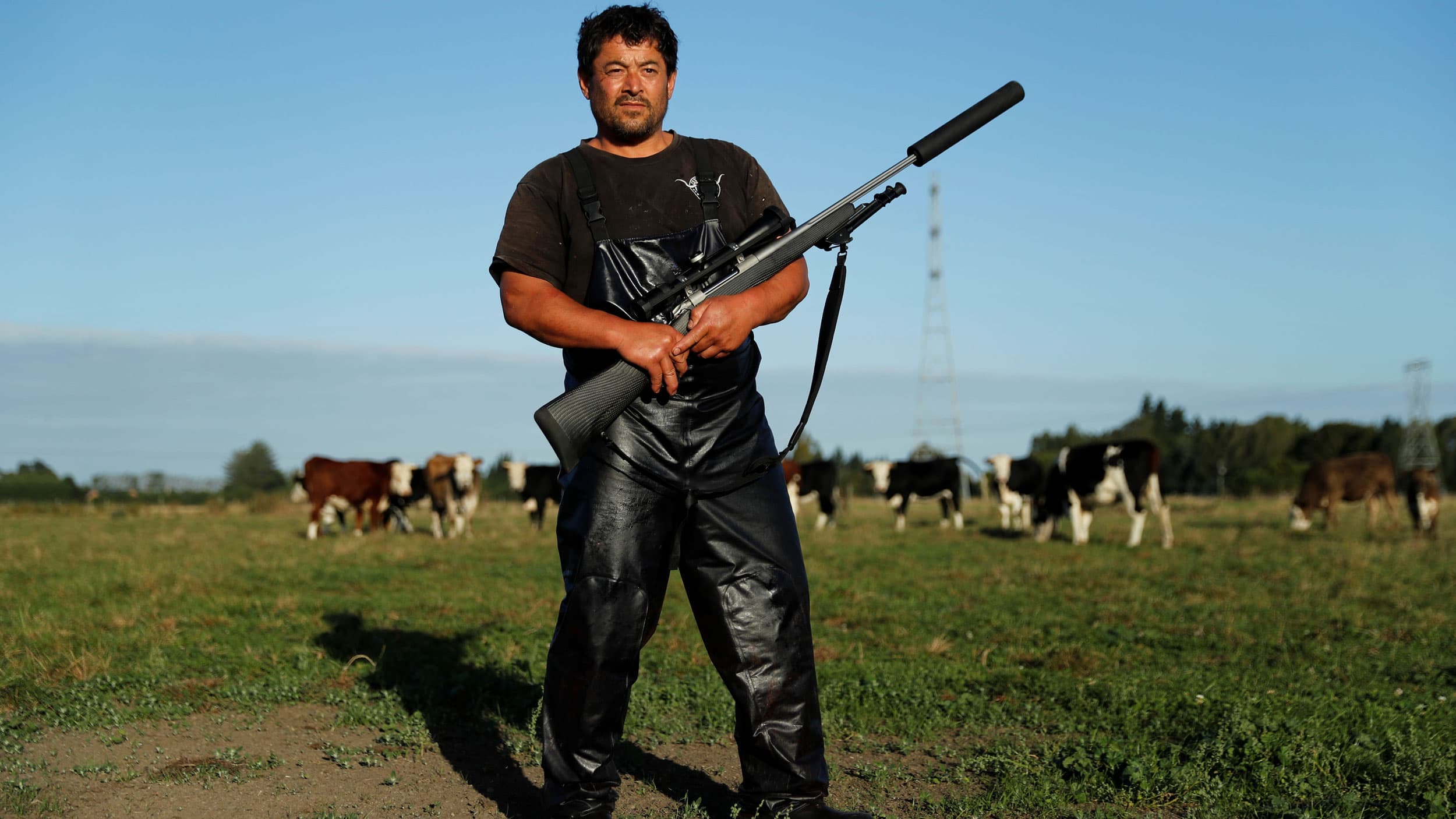 Noel Womersley is shown in dark overalls posing with a black Sako 85 hunting rifle.