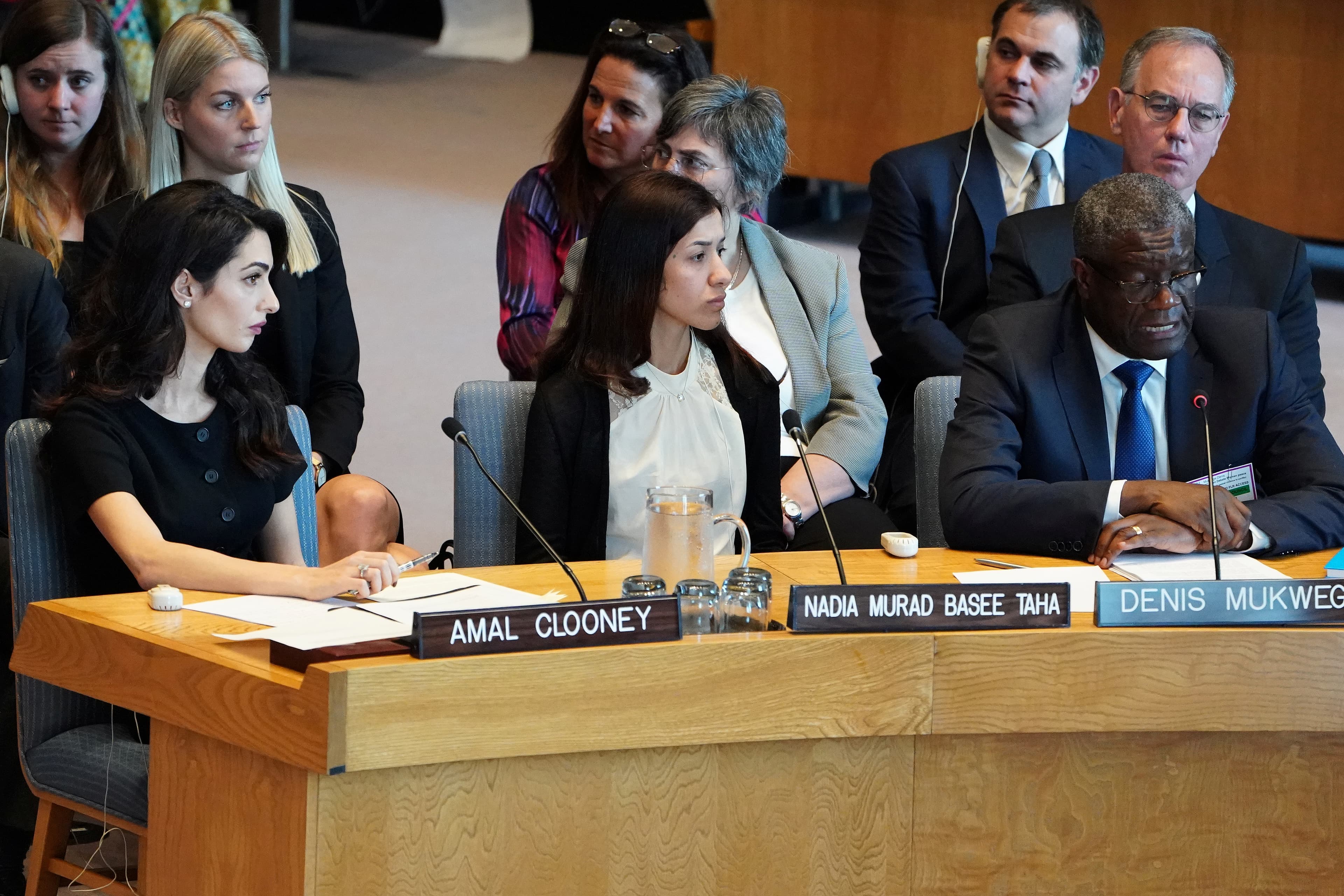 Nadia Murad sits in blue chair next to others listening to testimony.