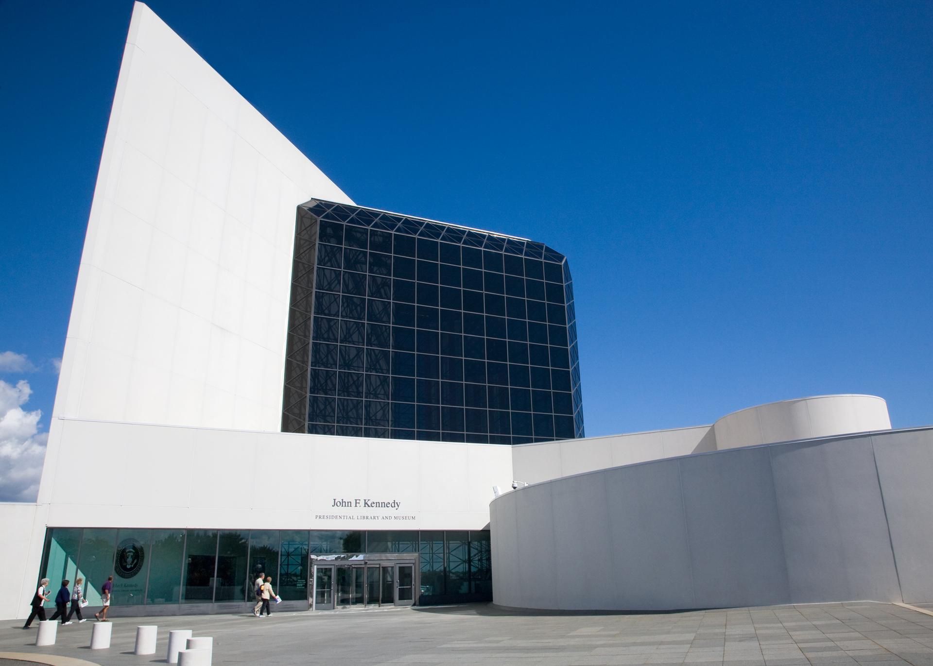 The glass and and concrete John F. Kennedy Presidential Library and Museum on a sunny day.