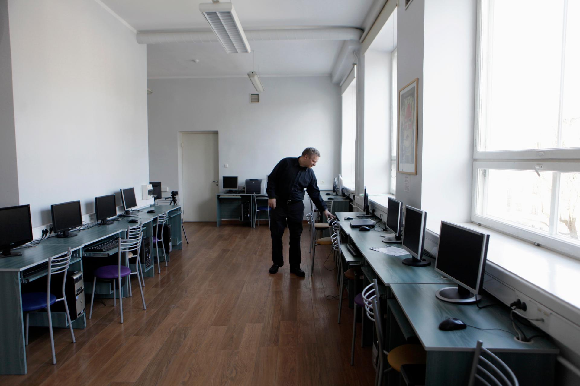 Informatics teacher Jevgeni Mihhailov inspects computers in an empty classroom in a school in Tallinn, Estonia, on March 7, 2012.