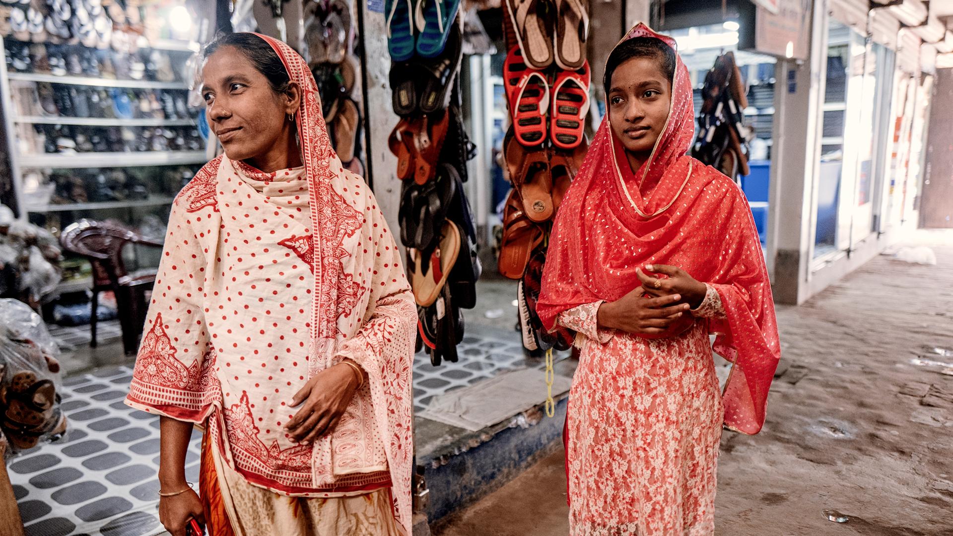 Rongmala Begum (L) and her 16-year-old daughter Mayna both work a the same garment factory making sweaters.