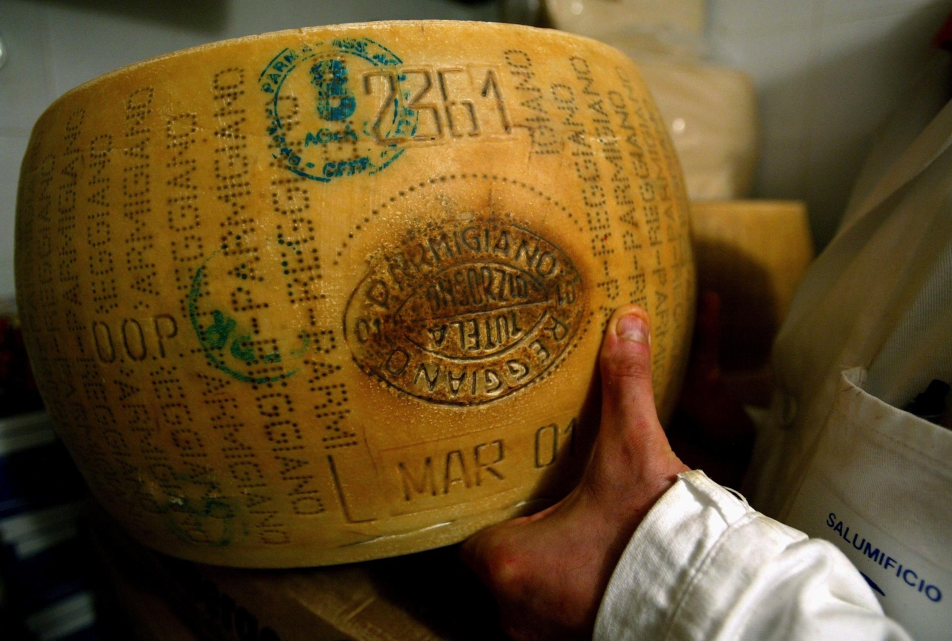 An Italian grocer shows off his Parmesan cheese