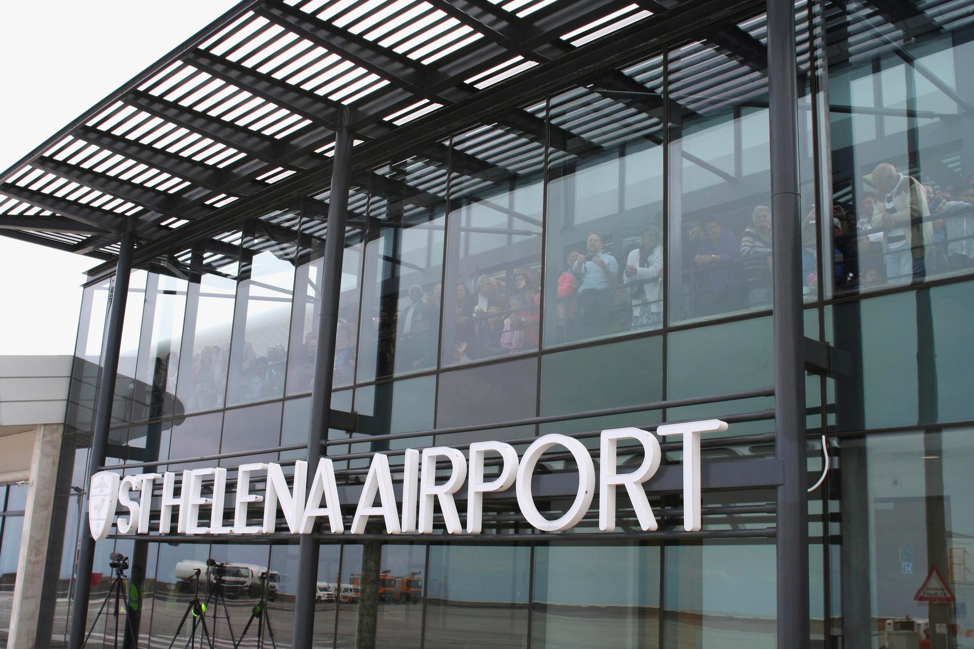 Onlookers peer through windows shortly after the first ever commercial flight landed at St. Helena airport