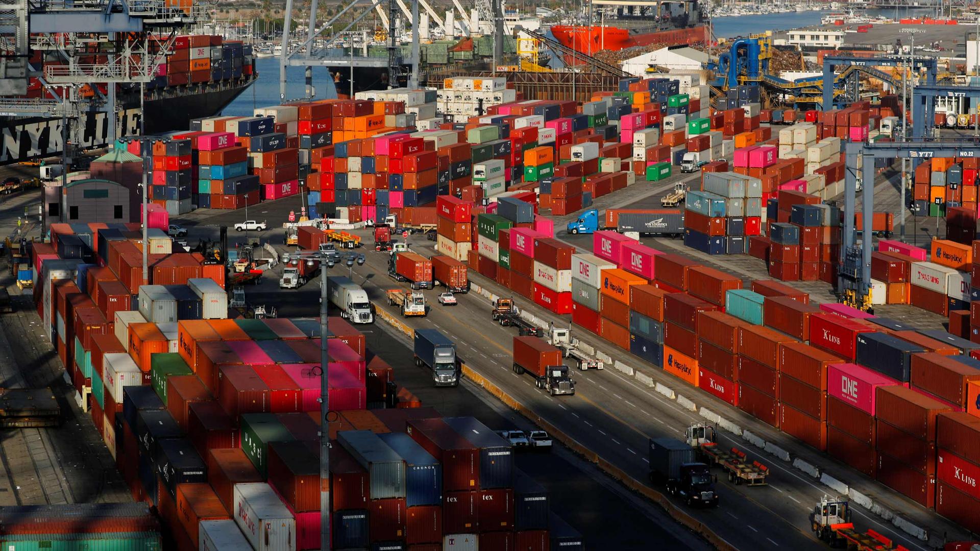 Hundreds of brightly colored shipping containers are stacked around a port