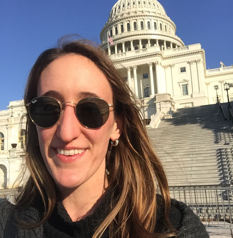 A headshot of a white woman in front of the Capitol building.
