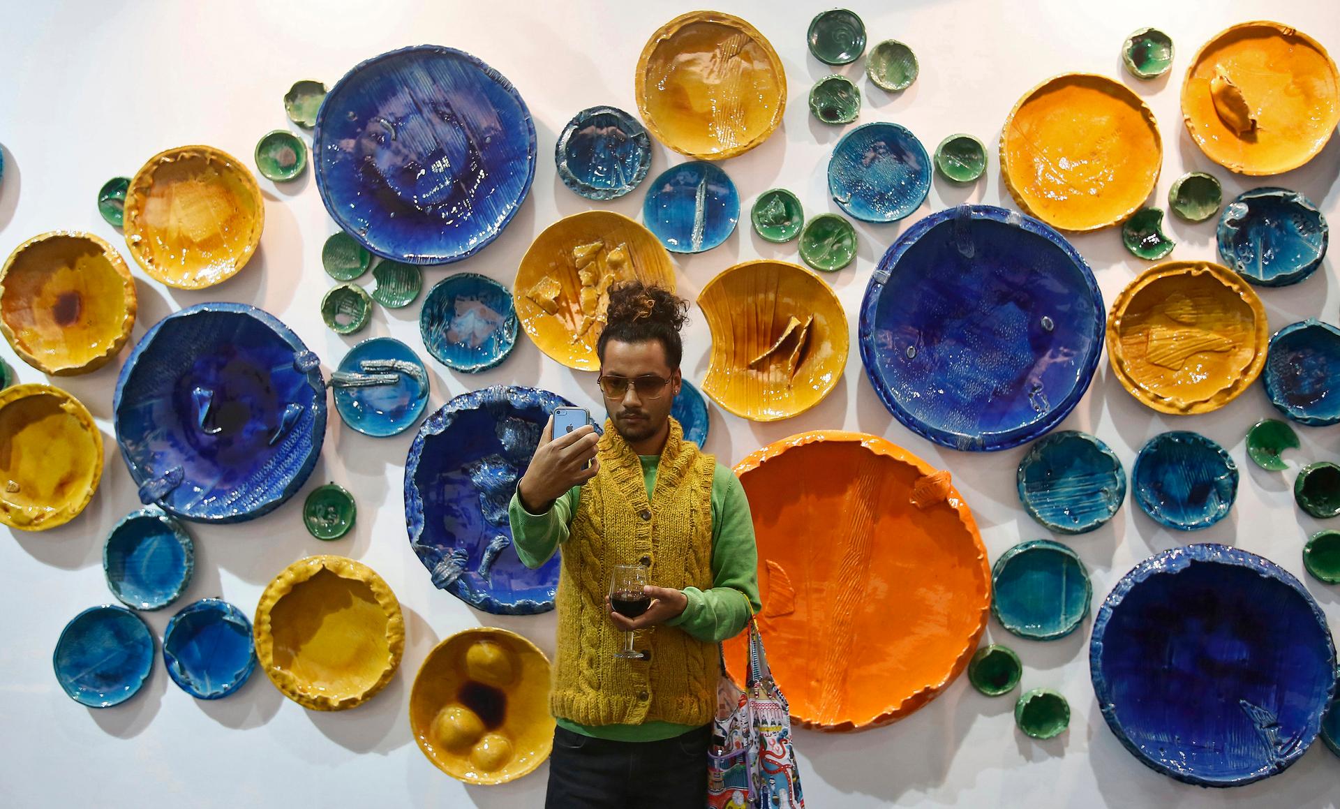 A visitor takes a "selfie" in front of art exhibit "Circle Uncircled" by artist Rahul Kumar.
