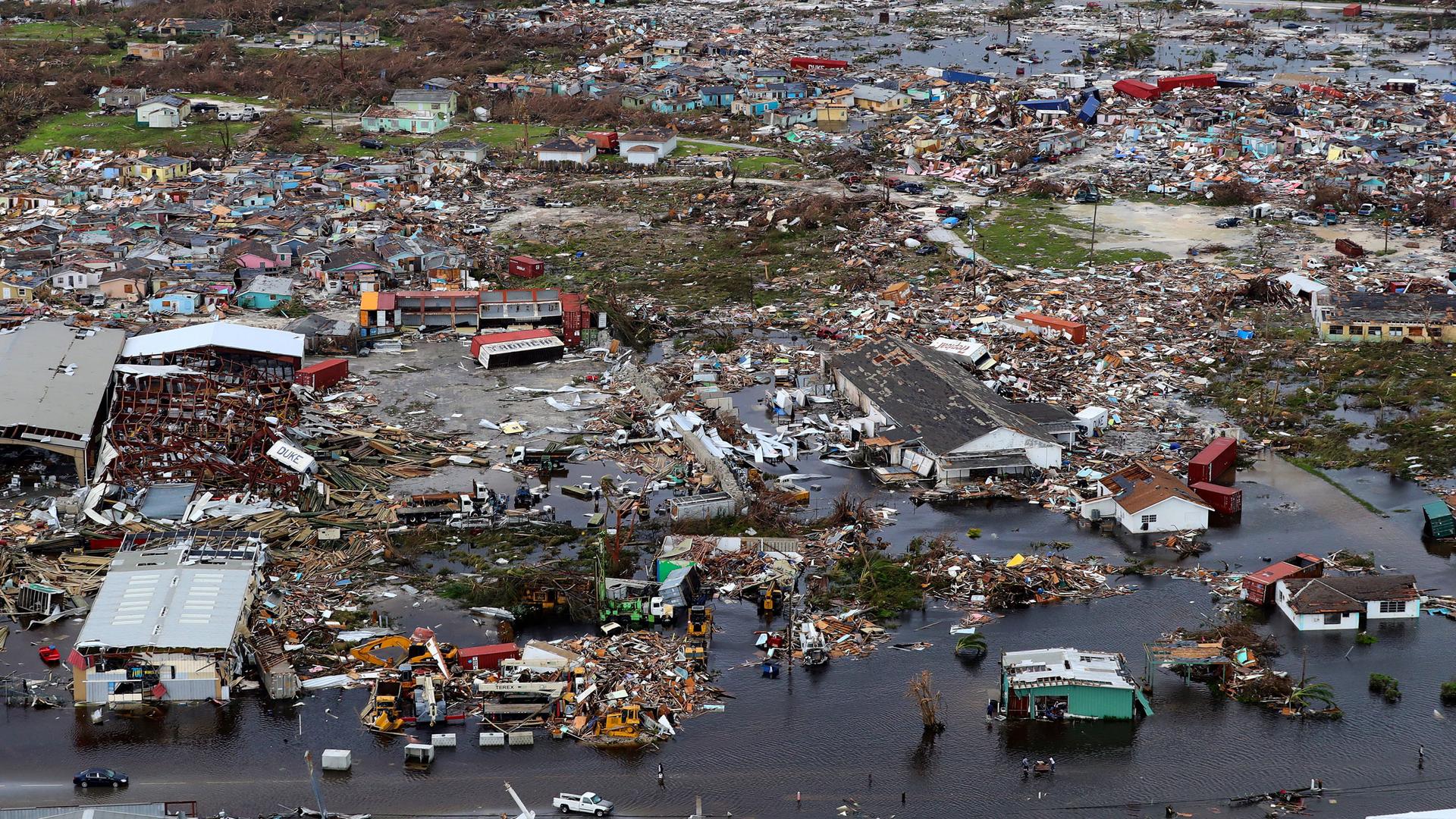 An aerial photograph showing flooded buildings and debris covering much of the landscape.