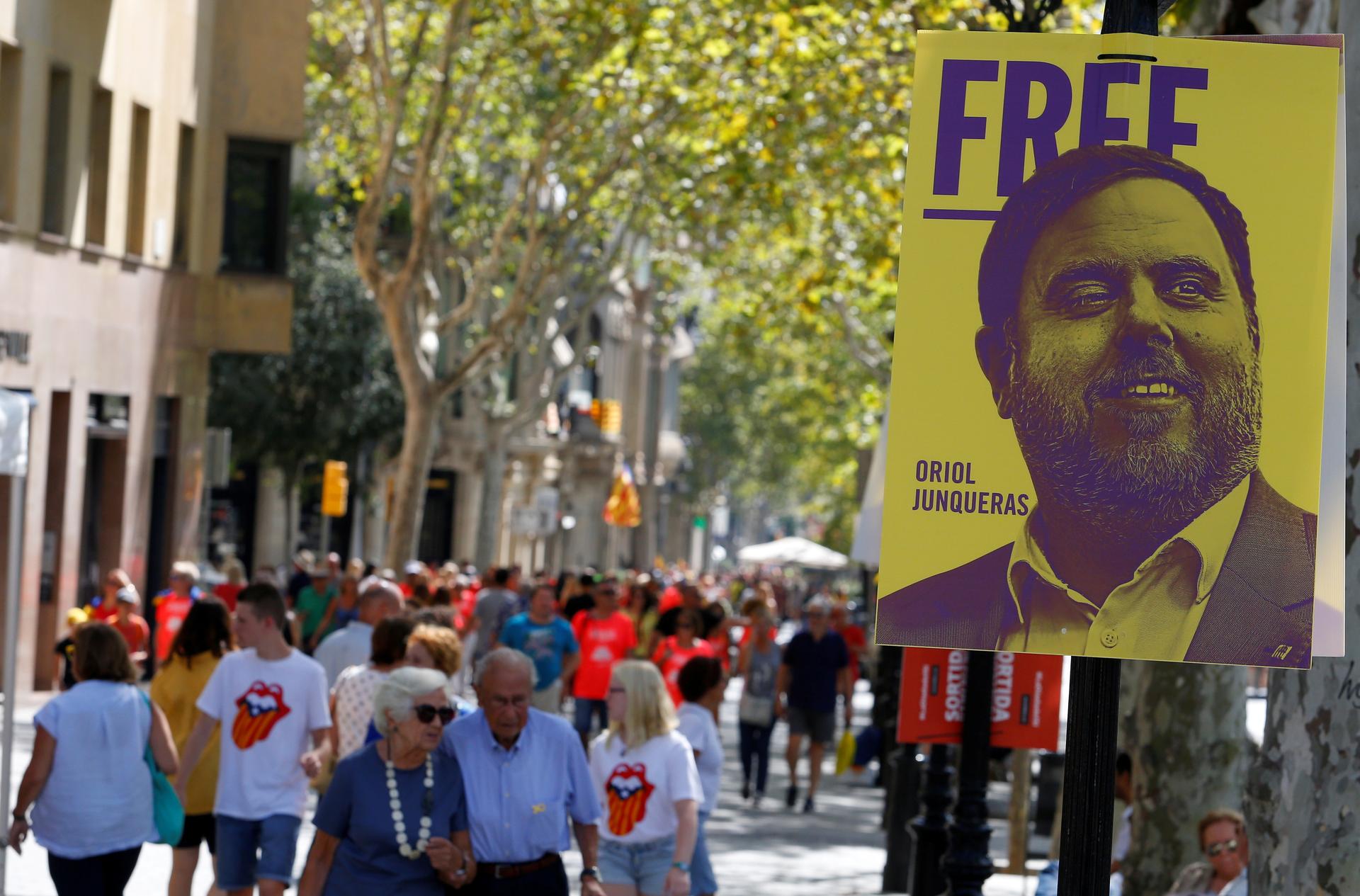 Protesters carry banner with yellow and blue image of separatist leader