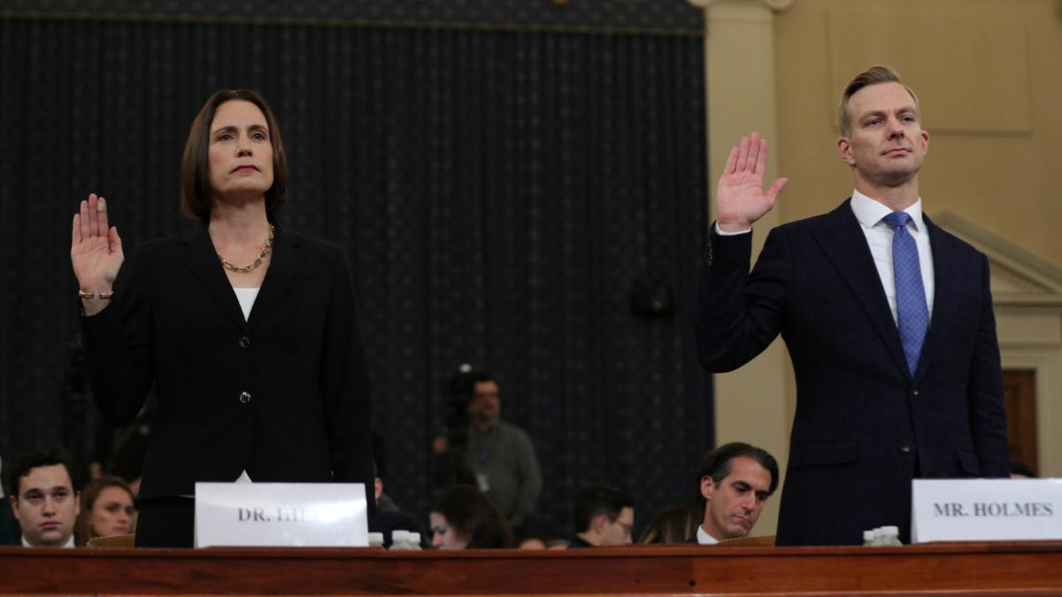 A man and a woman take the oath by raising their right hand.