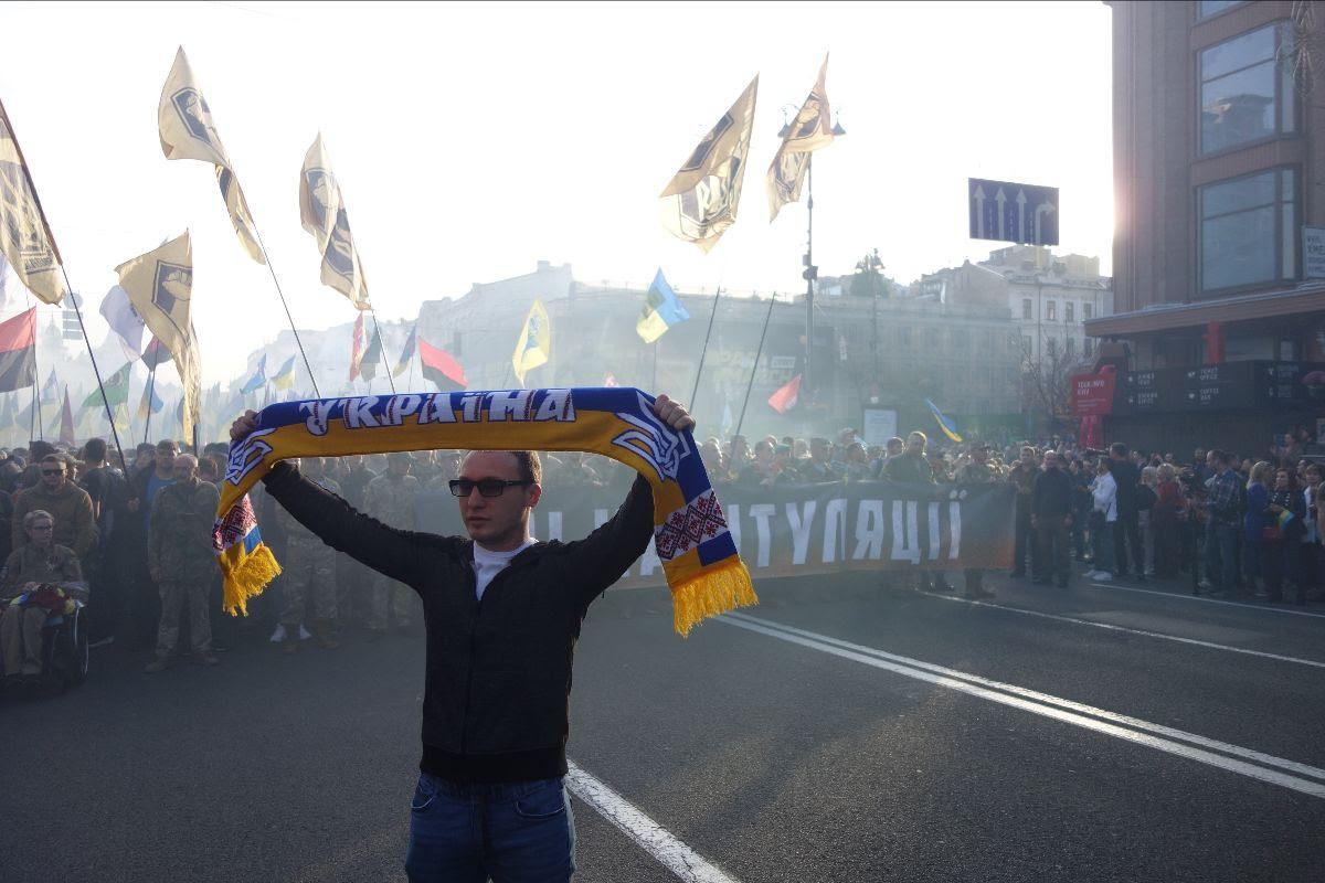 A protester holding a "Ukraine" scarf poses during the "march against capitulation" on Oct. 14, 2019, in Kyiv, Ukraine. 