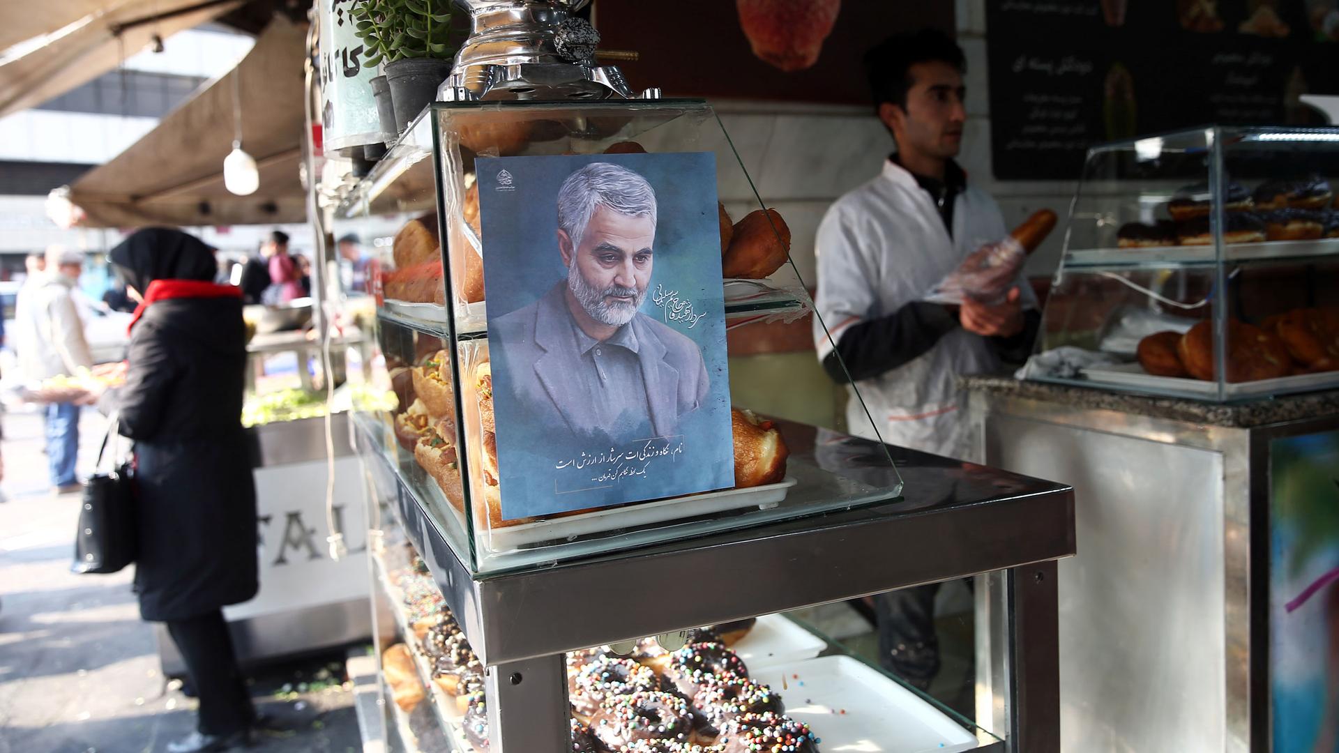 A portrait painint of of Iranian Maj. Gen. Qasem Soleimani is shown on a glass case in a confectionery shop.