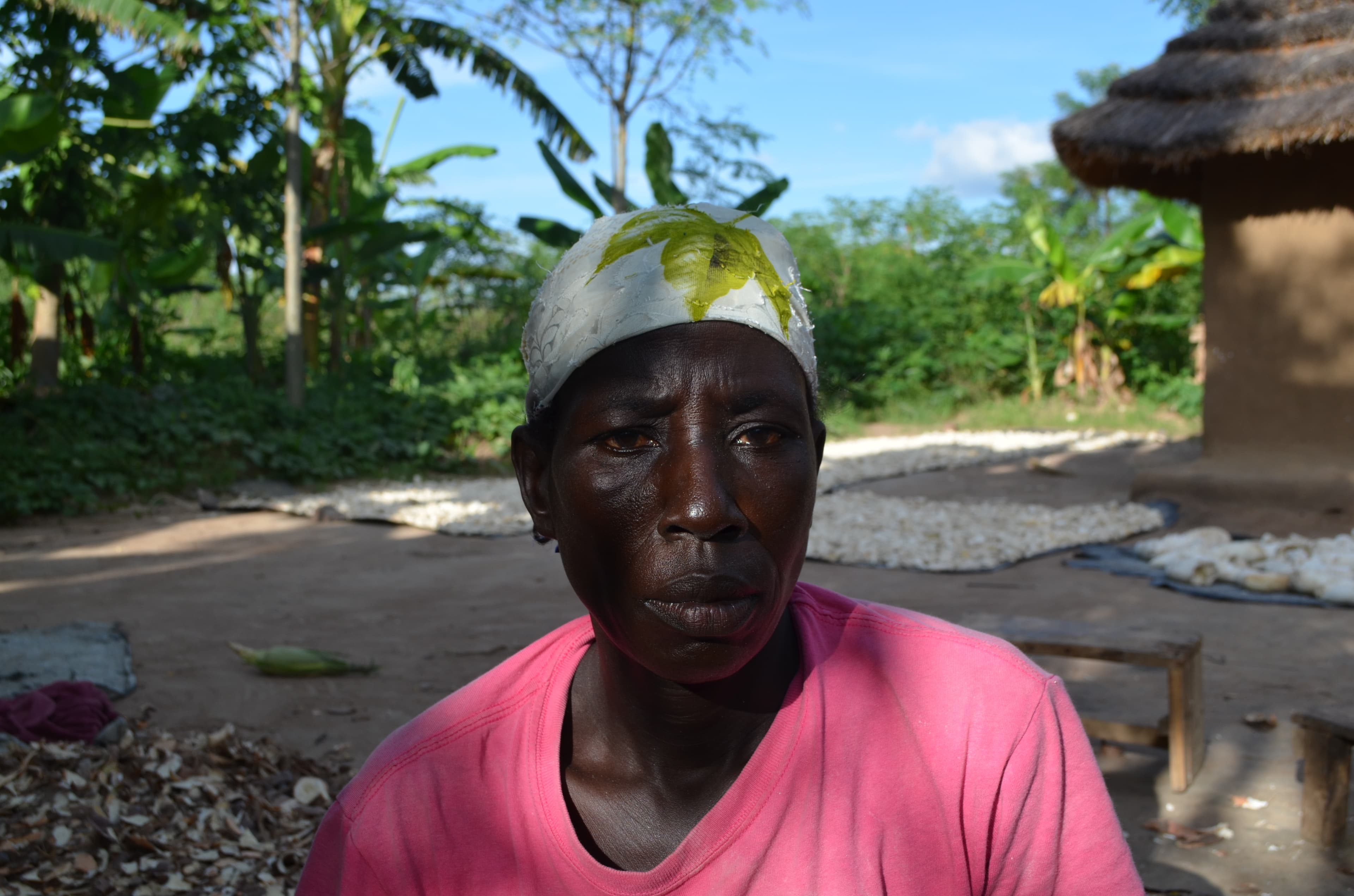 A woman wears a pink shirt and a head wrap.