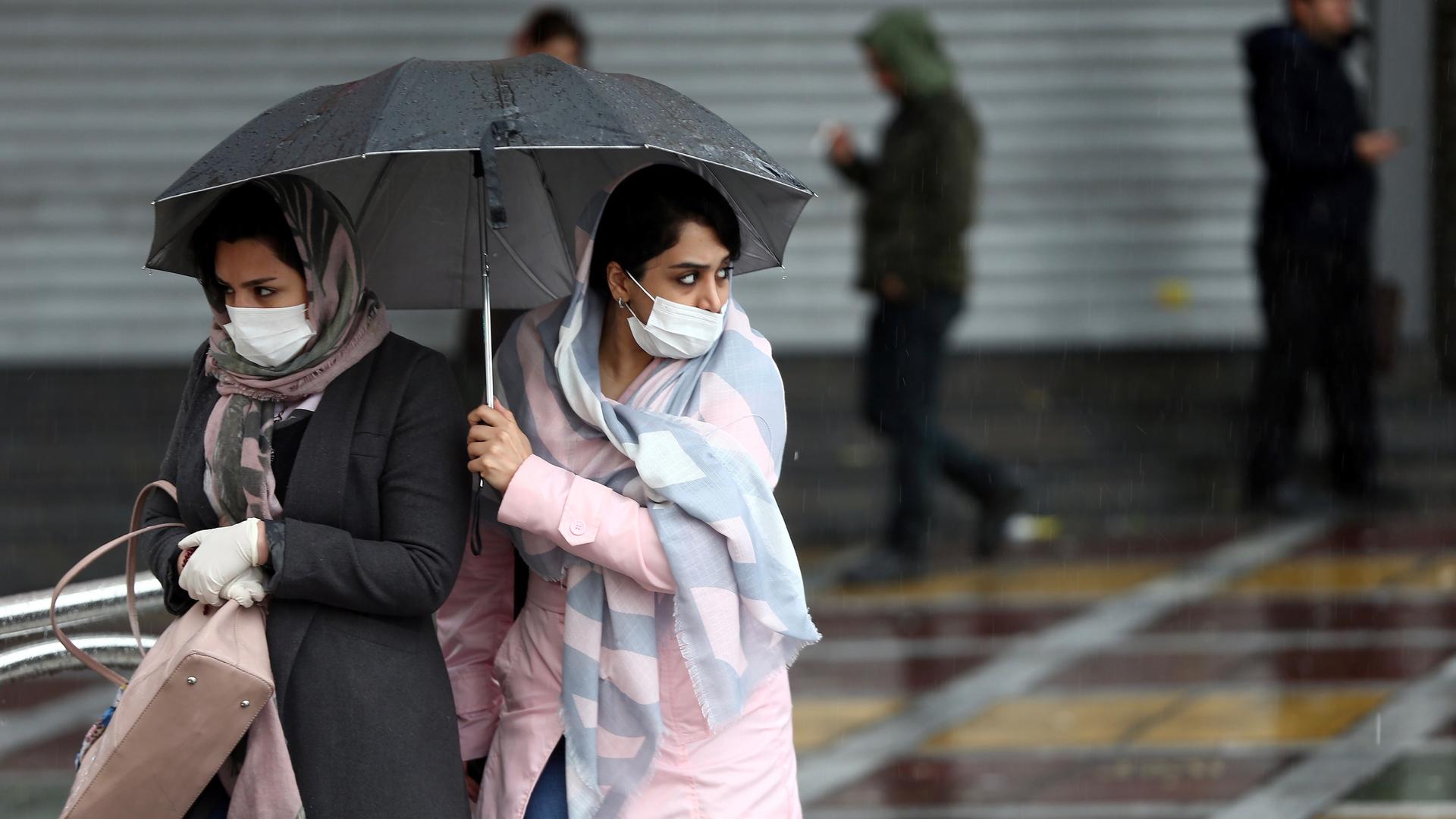 Iranian women wear protective masks to prevent contracting coronavirus as they walk in the street in Tehran, Iran, Feb. 25, 2020.
