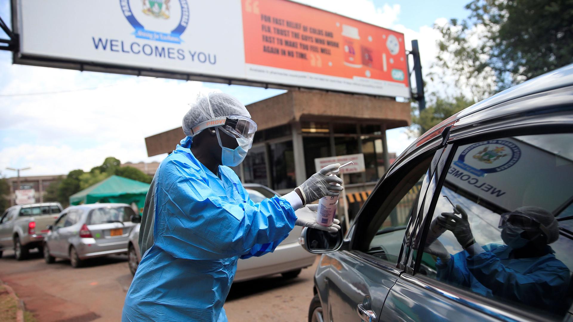 A health worker screens and sanitises visitors to prevent the spread of coronavirus disease (COVID-19) outside a hospital in Harare, Zimbabwe March 26, 2020.