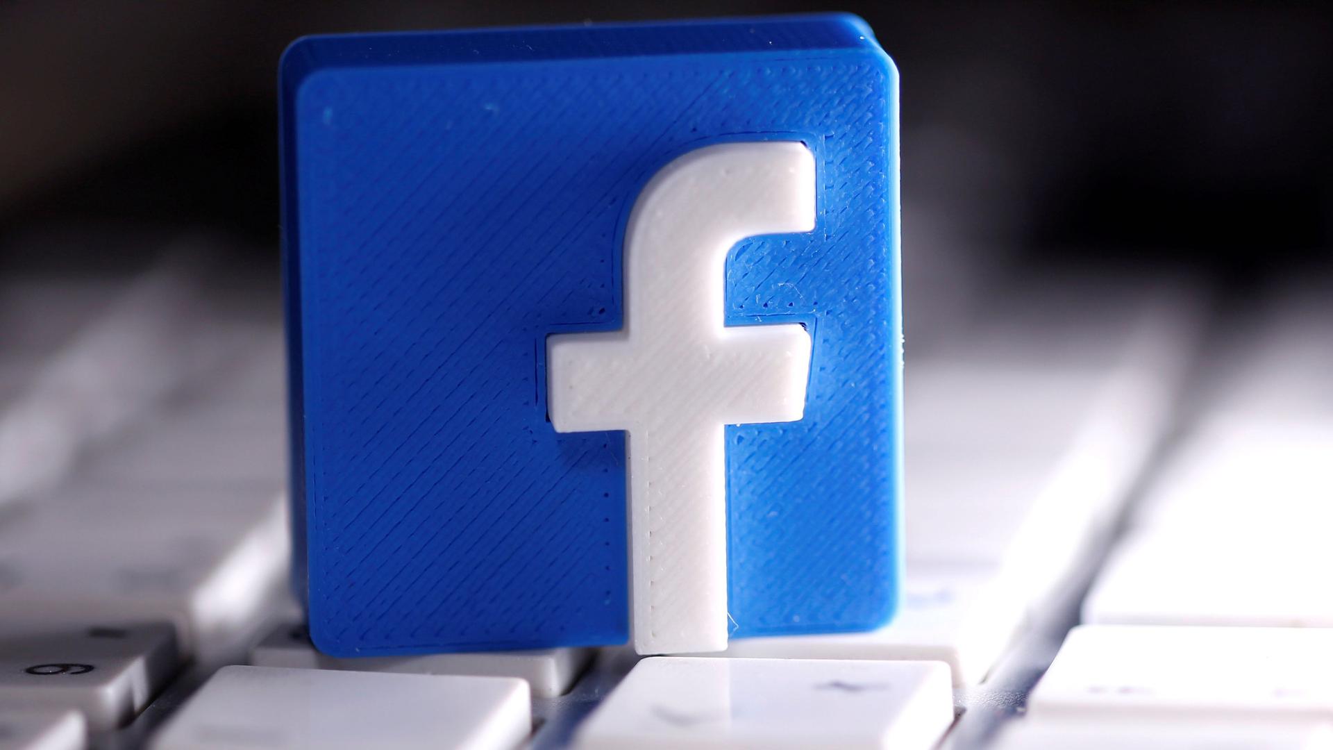 A 3D-printed Facebook logo is seen placed on a keyboard in this illustration taken March 25, 2020.