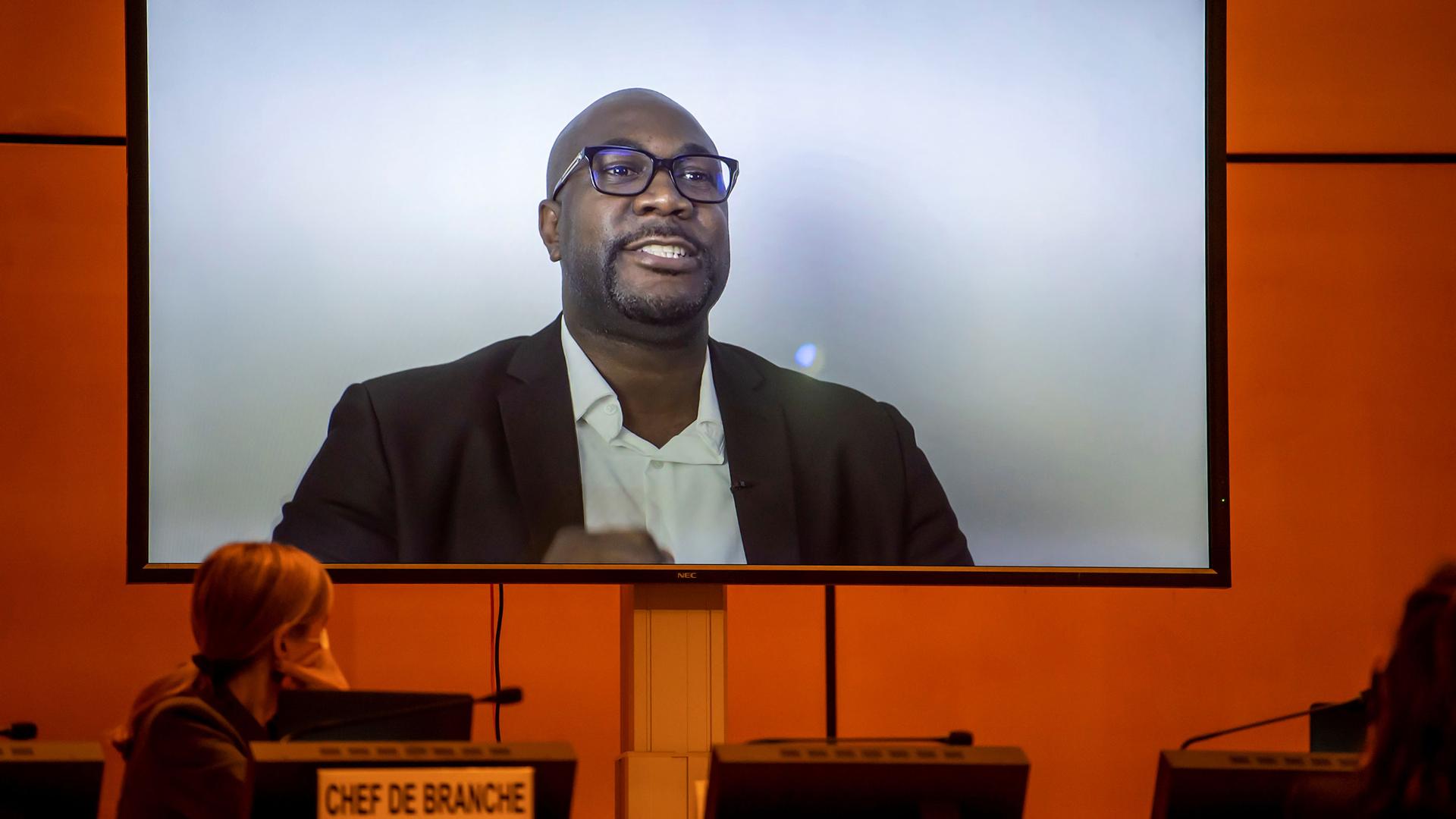 George Floyd's brother, Philonise Floyd, is shown wearing glasses and a blazer while speaking on screen via video message.