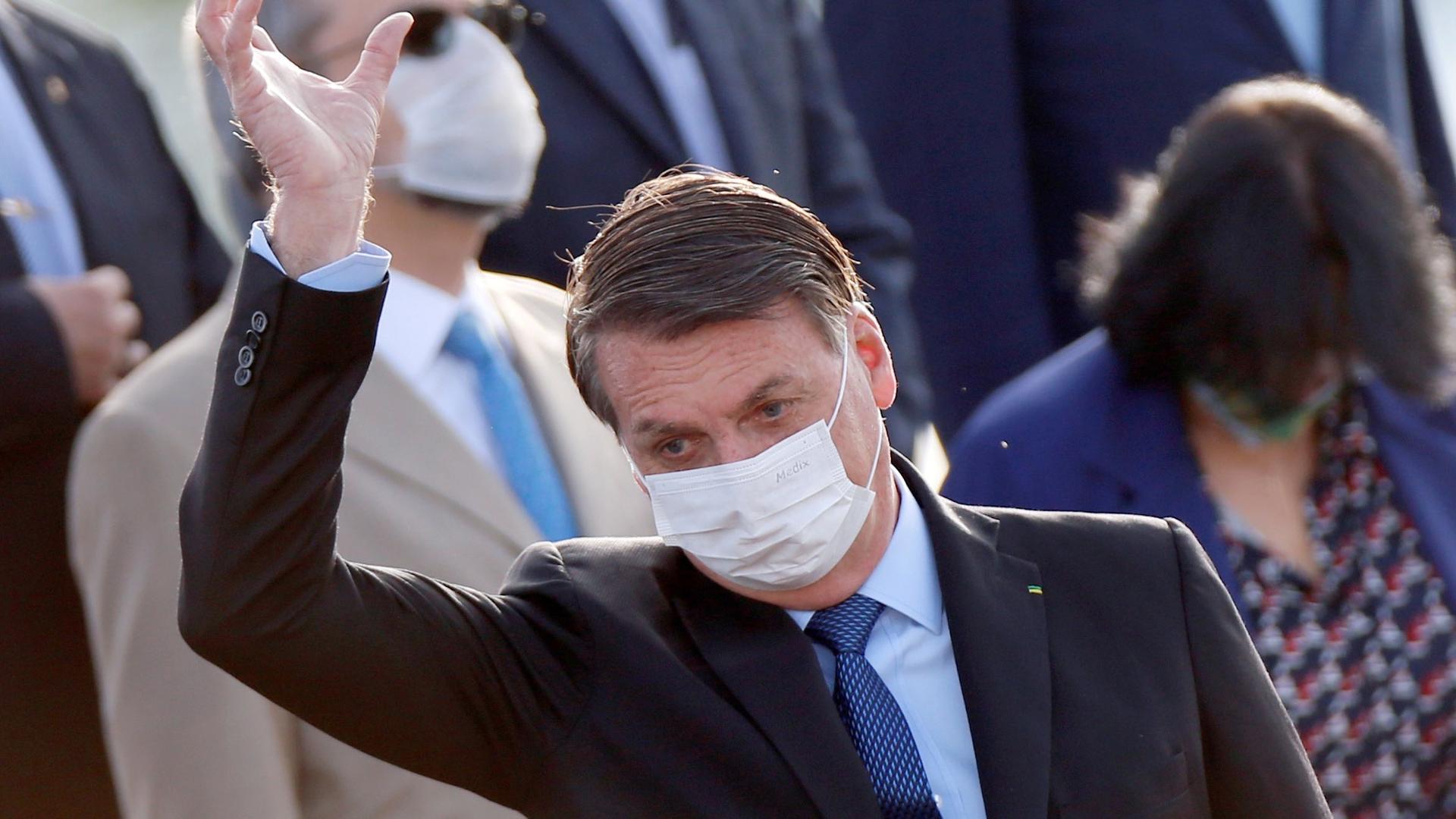 Brazil's President Jair Bolsonaro wearing a protective face mask gestures during a national flag hoisting ceremony in front of Alvorada Palace, amid the coronavirus disease (COVID-19) outbreak in Brasilia, Brazil, June 9, 2020.