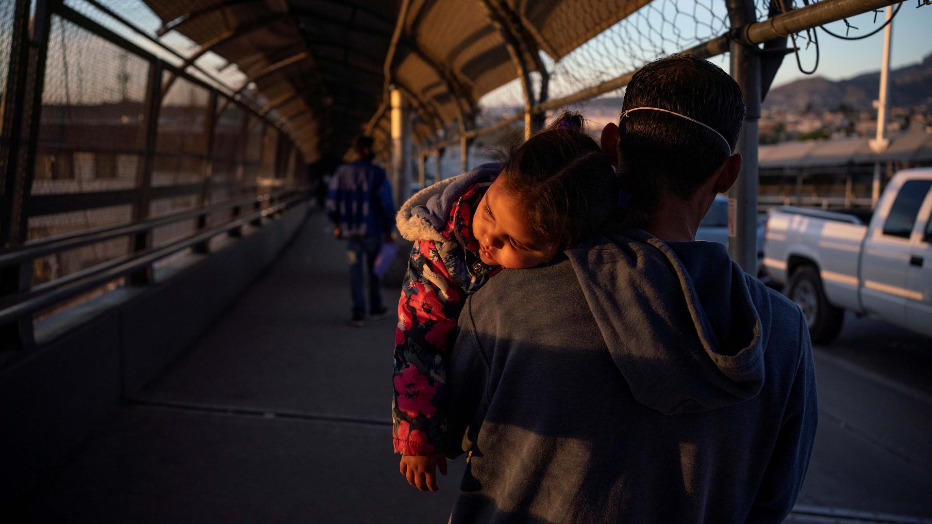 A migrant father and child returns to Ciudad Juárez after he had his family's court dates changed by Customs and Border Protection on the Paso del Norte International Bridge after court cancelations amid the coronavirus disease (COVID-19) outbreak in Ciud