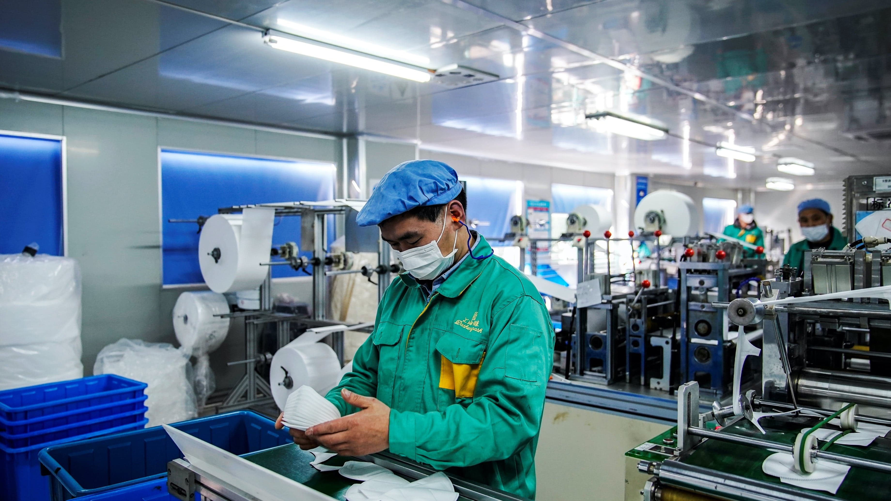 A person wears a mask on an assembly line at a factory