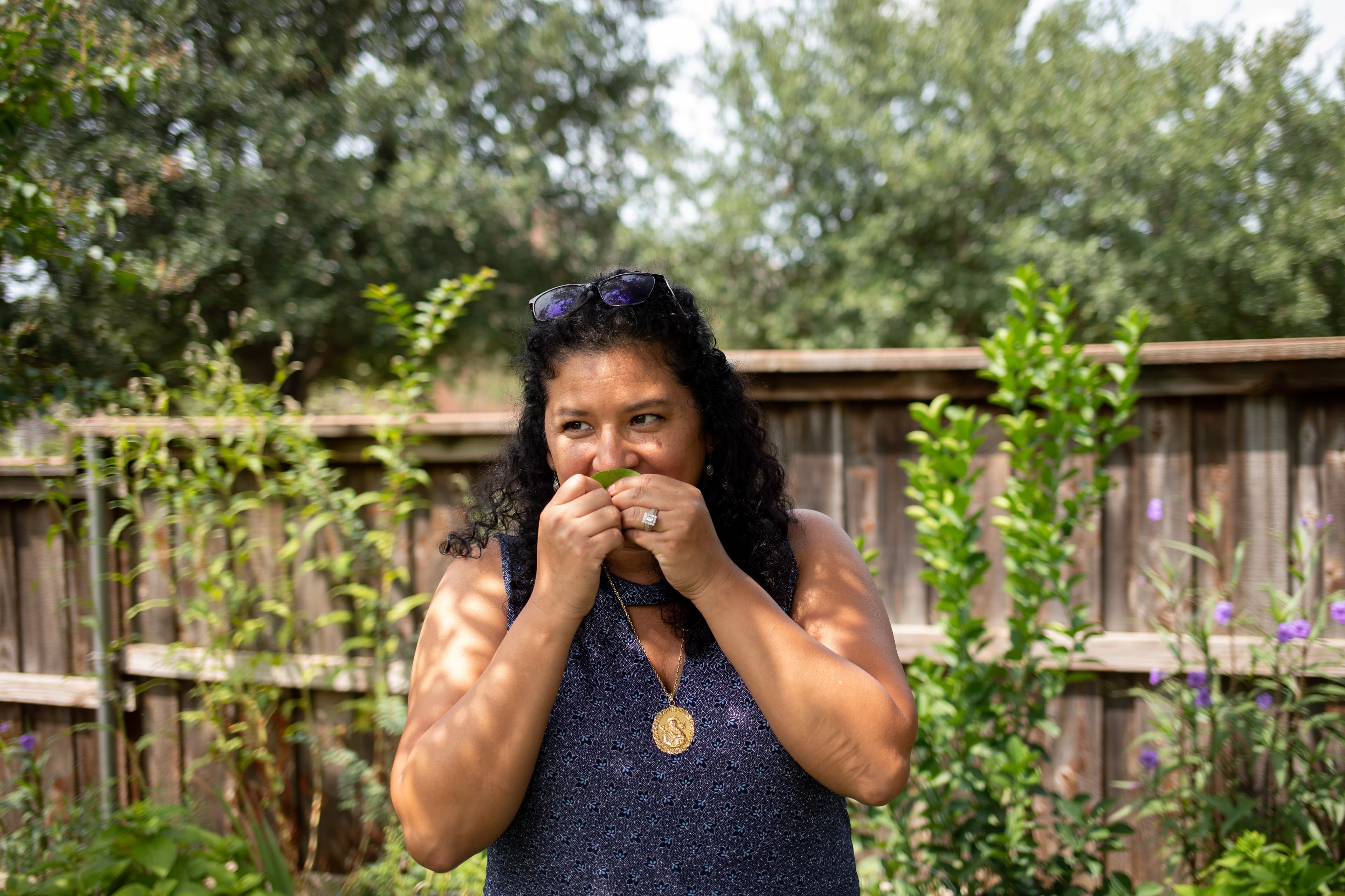 Xochitl Ortiz smells a leaf from a tree in the family backyard in Fort Worth, Texas.