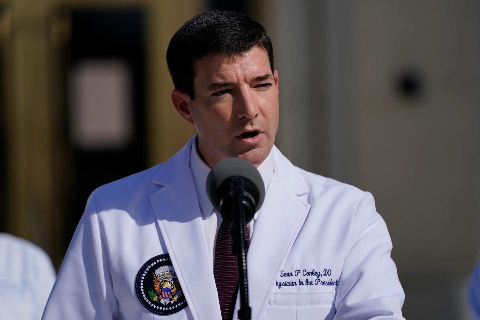 Dr. Sean Conley, physician to US President Donald Trump, is shown wearing a white medical jacket with a US presidential shield page on the breast.