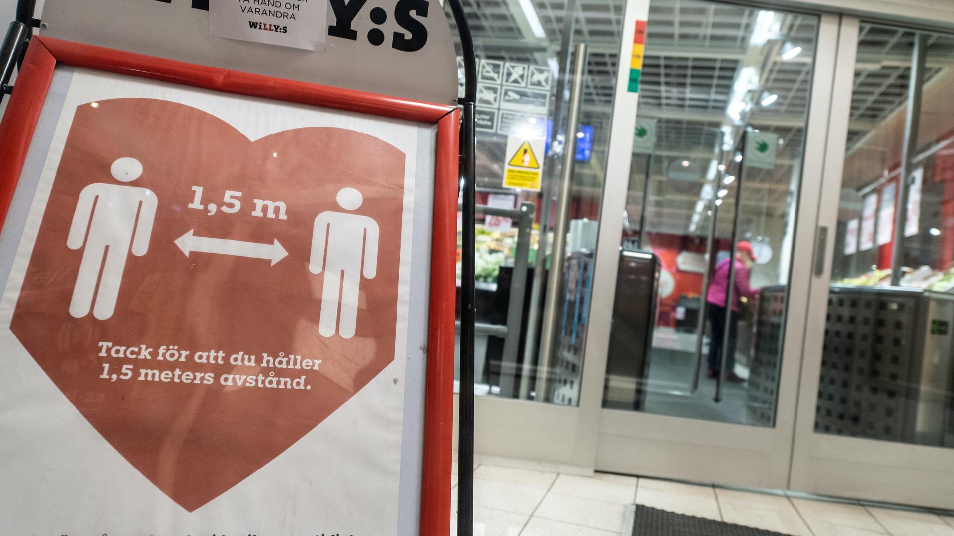A sign reminding customers about social distancing is placed at the entrance to a grocery store in central Stockholm.