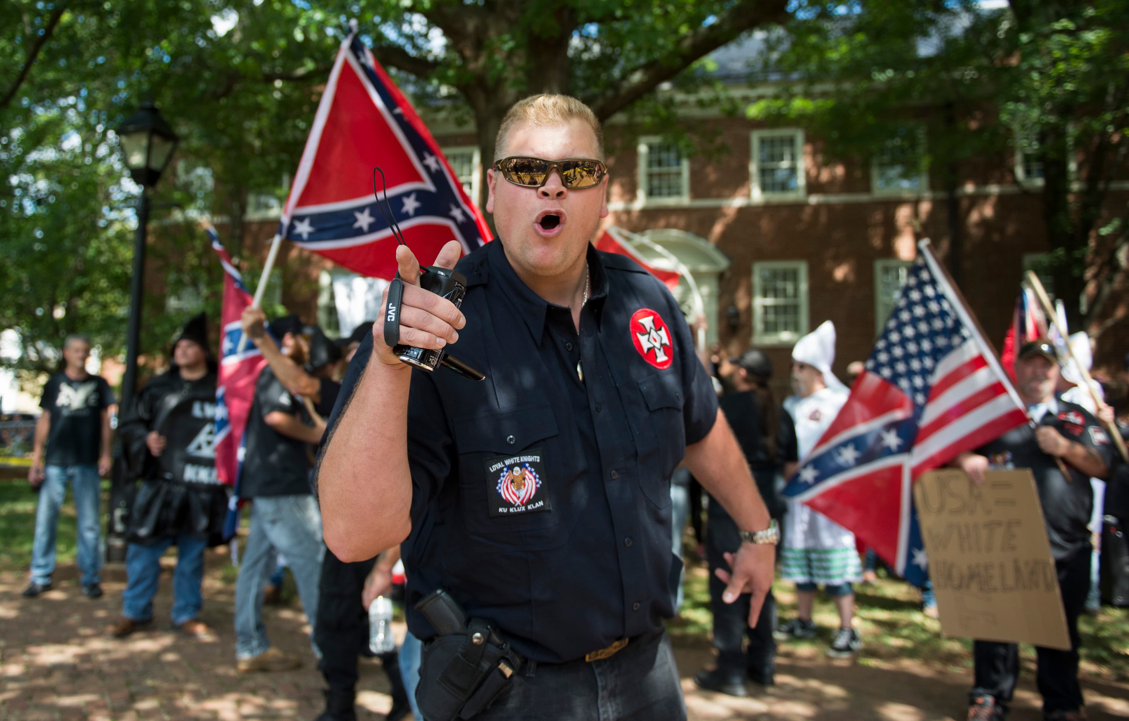 A white supremacist cheers with a crowd.