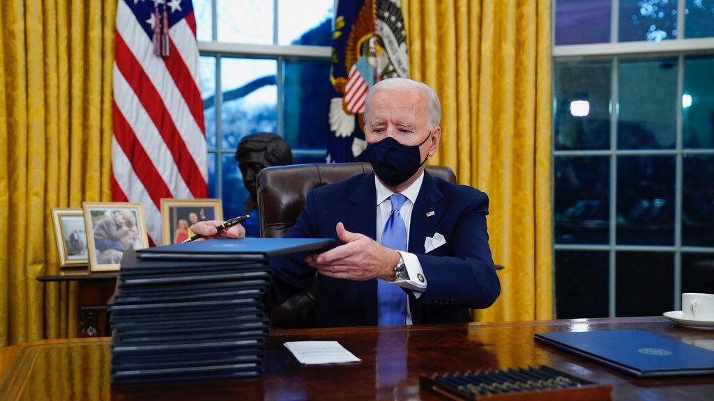 President Joe Biden signs his first executive orders in the Oval Office of the White House in Washington on Jan. 20, 2021. Six of Biden's 17 first-day executive orders dealt with immigration, such as halting work on a border wall in Mexico and lifting a t