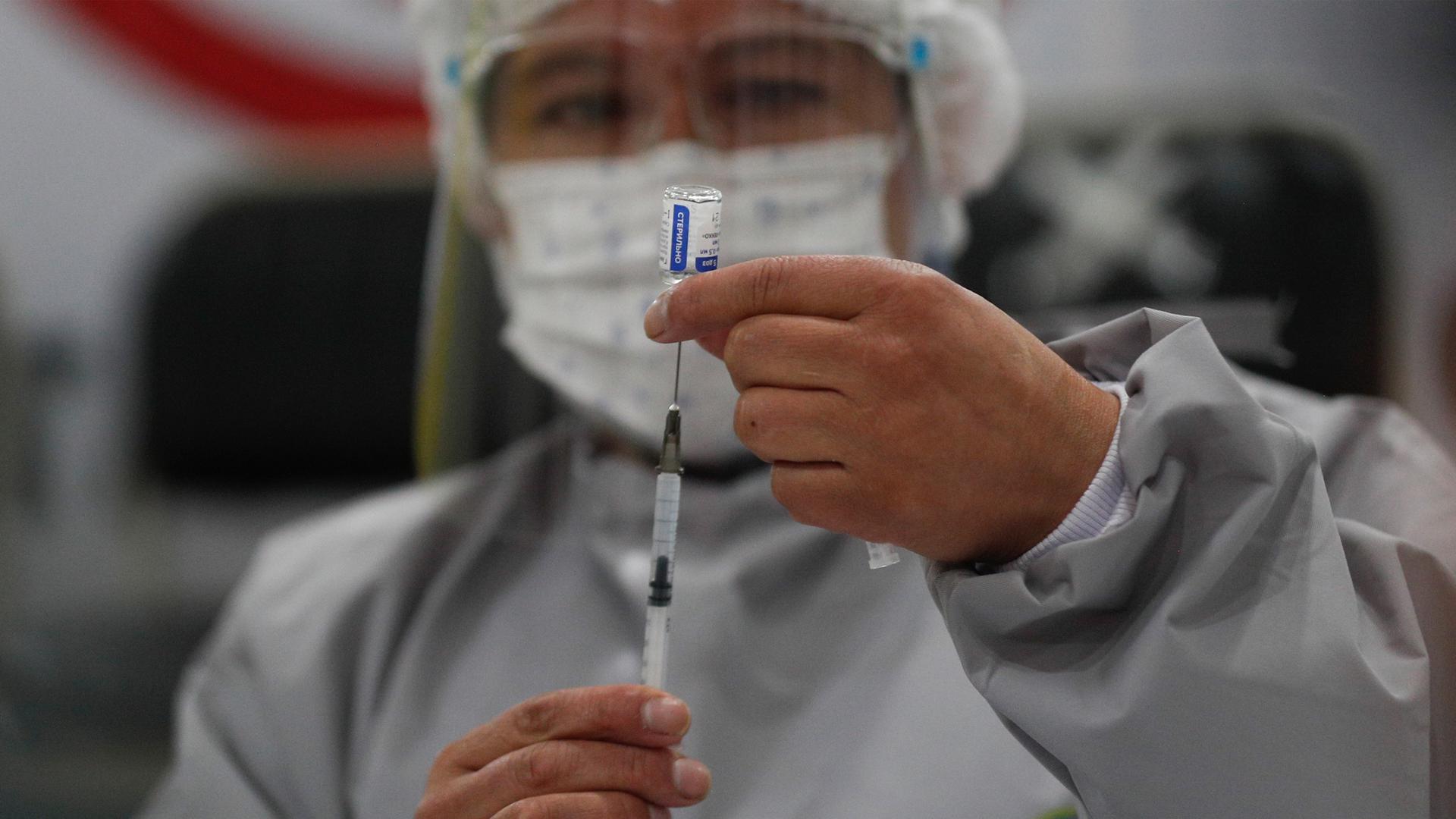 A health care worker prepares a dose of Russia's Sputnik V COVID-19 vaccine, at the Del Norte Hospital in El Alto, Bolivia, on Saturday, Jan. 30, 2021.