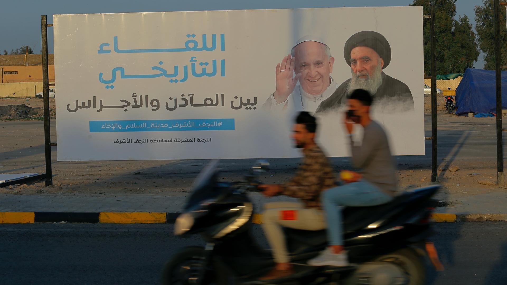Iraqis put up a poster announcing the upcoming visit of Pope Francis and a meeting with a revered Shiite Muslim leader, Grand Ayatollah Ali al-Sistani, right, in Najaf, Iraq, March 4, 2021.