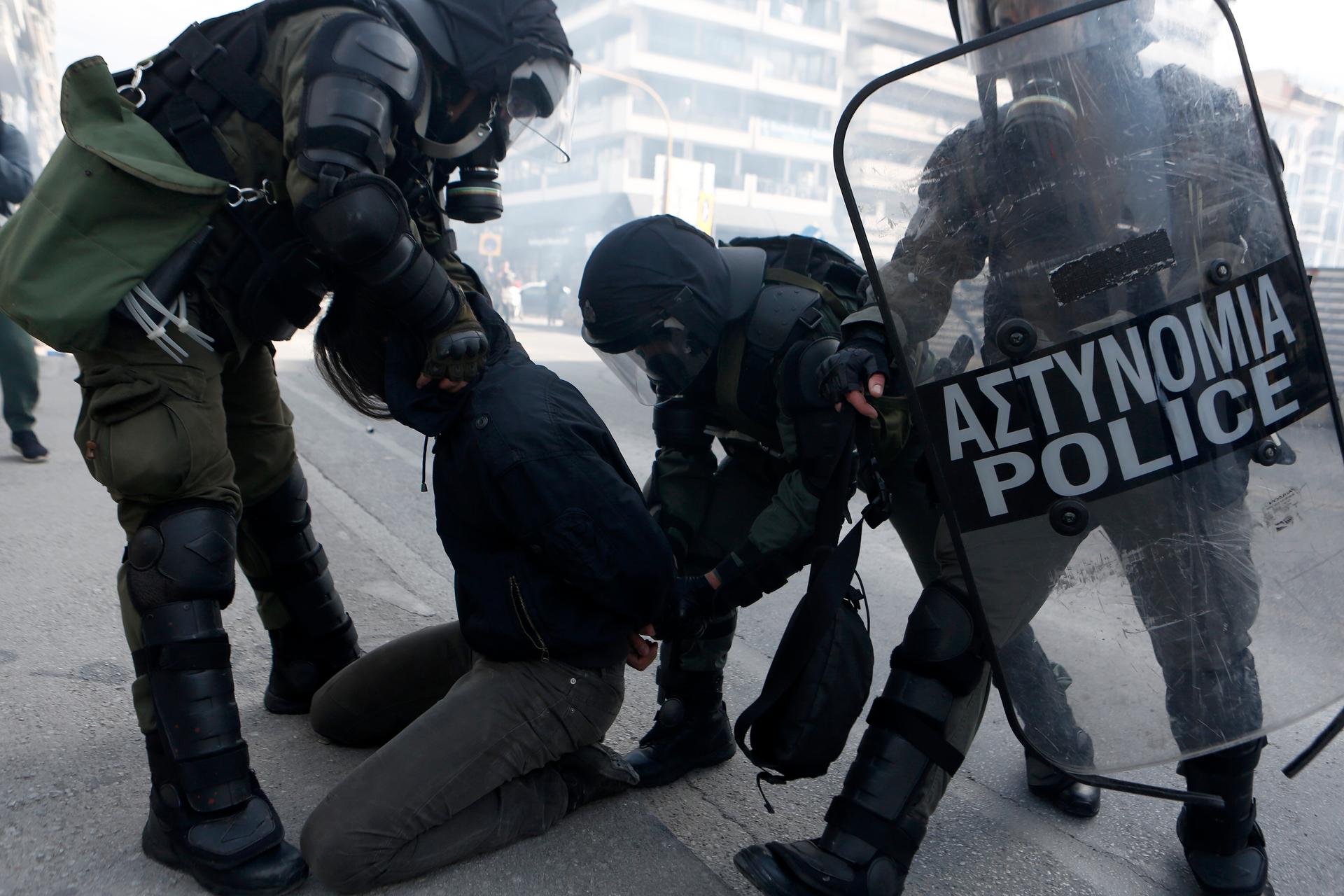 Riot police detain a man during clashes in the northern city of Thessaloniki, Greece, March 11, 2021.