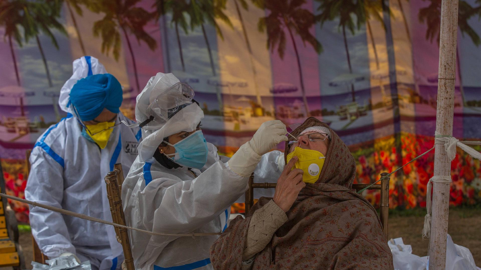 A health worker takes a nasal swab sample of a Kashmiri woman to test for COVID-19 in Srinagar, Indian-controlled Kashmir on Friday, Dec. 11, 2020. 