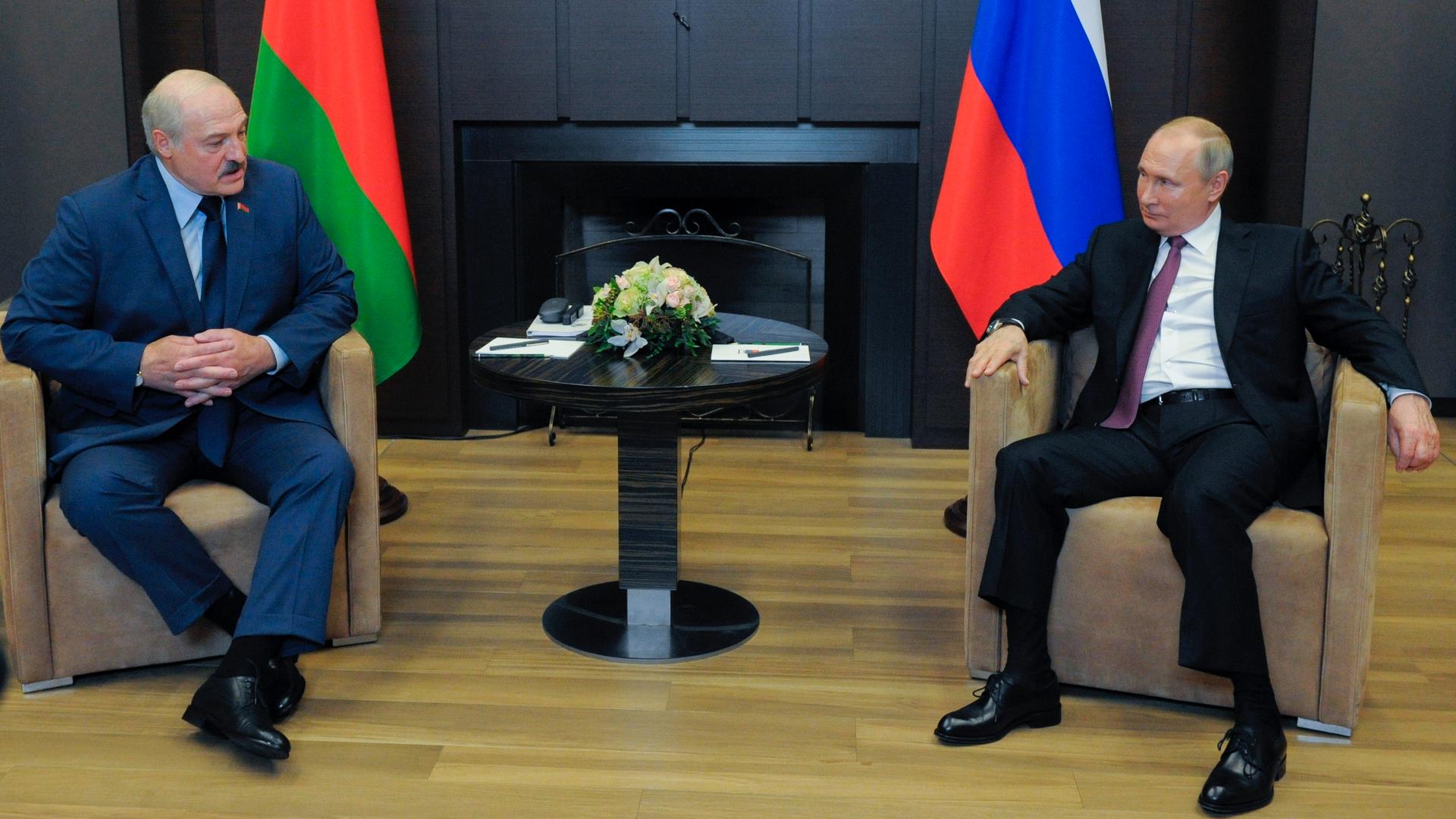 Russian President Vladimir Putin, right, and Belarusian President Alexander Lukashenko talk to each other during their meeting in the Black Sea resort of Sochi, Russia