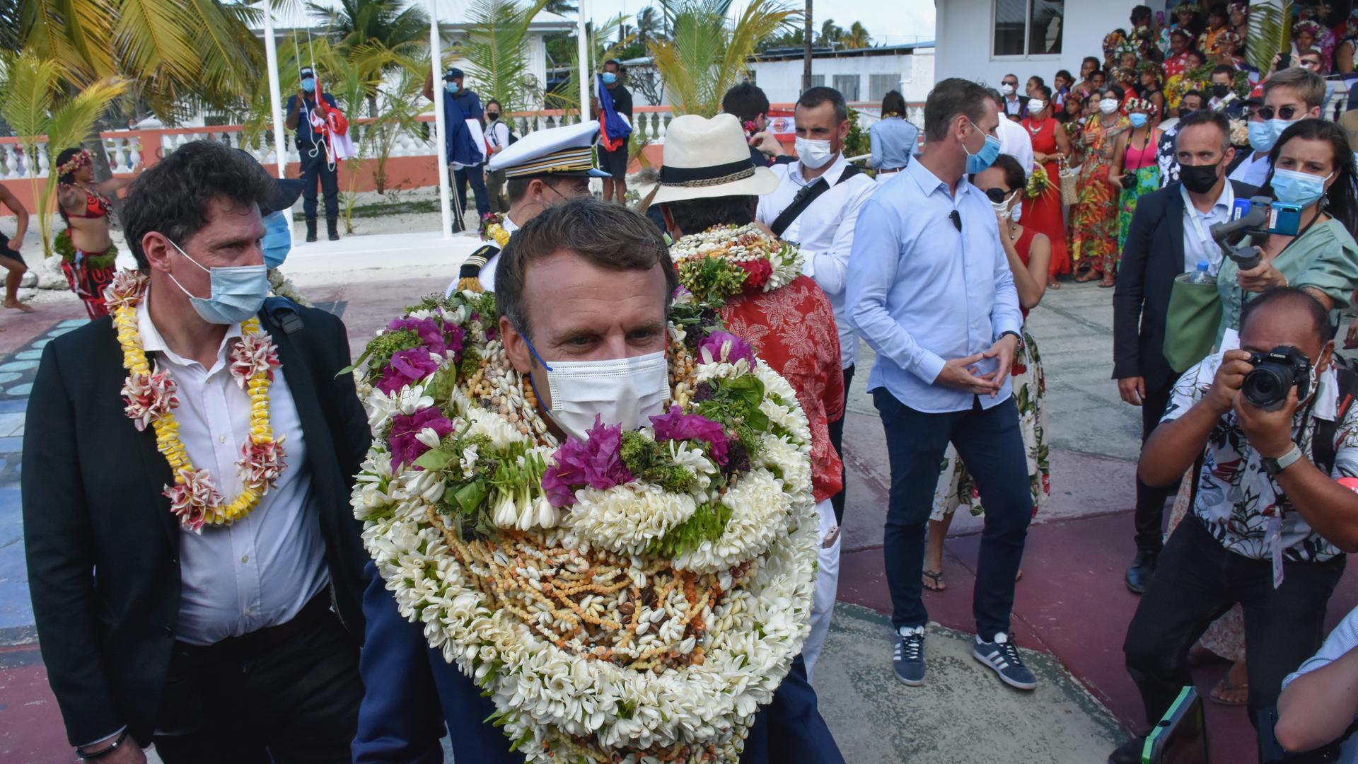 France's President Emmanuel Macron wore flower leis and seashell necklaces as he arrived at the Manihi Atoll, 312 miles northeast of Tahiti, French Polynesia, in the Pacific Ocean, July 26, 2021. 
