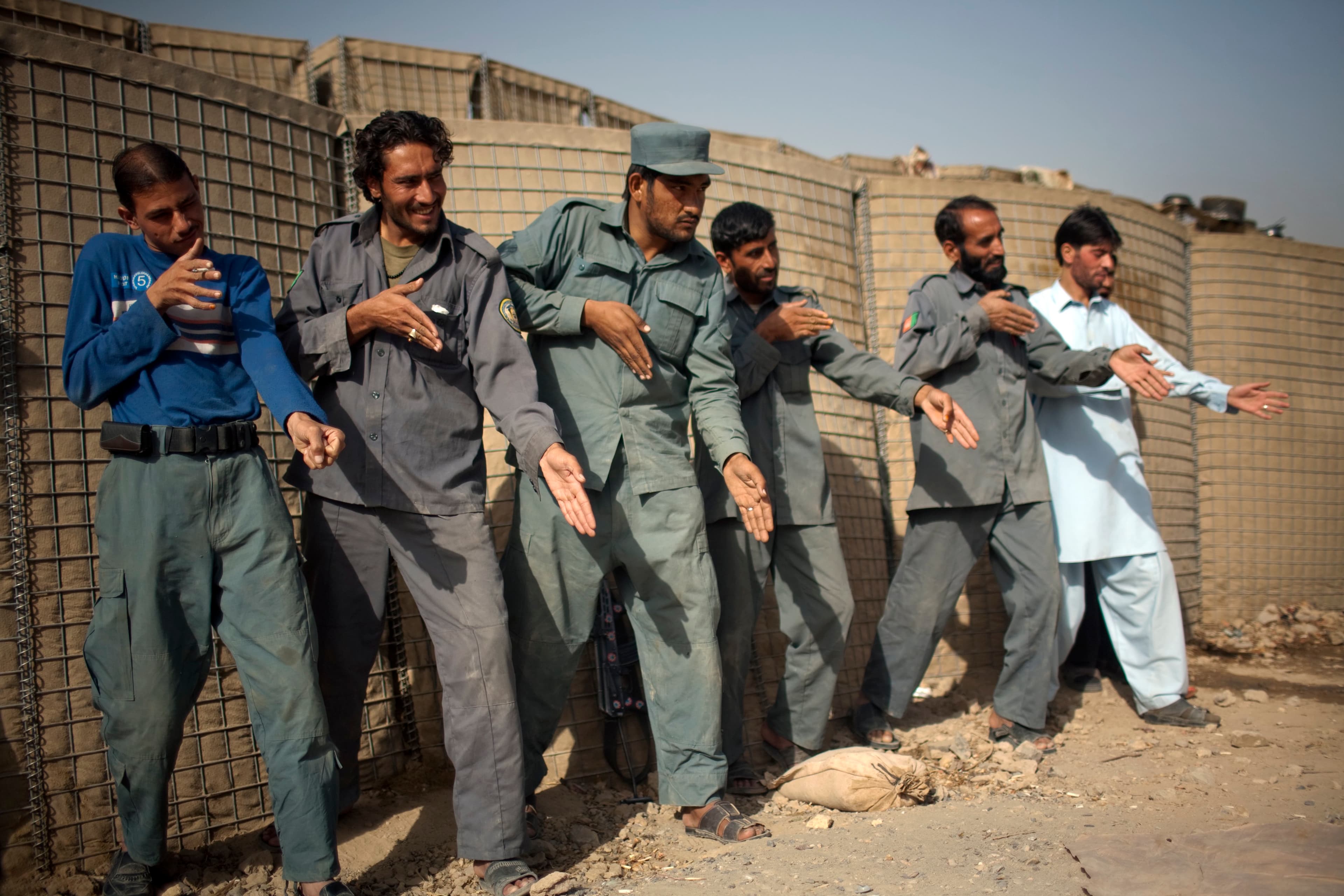 Afghan policemen simulate weapons orientation during a training session with U.S. soldiers from 2nd PLT Diablos 552nd Military Police Company, on the outskirts of Kandahar City, Afghanistan, on Oct. 26, 2010.