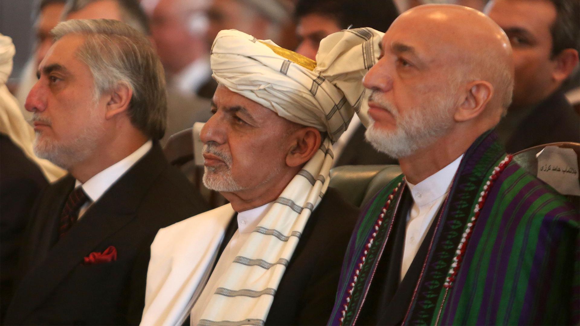 Afghan President Ashraf Ghani, center, former President Hamid Karzai, right, and Chief Executive Abdullah Abdullah, left, watch the live broadcast of Gulbuddin Hekmatyar after the signing of a peace treaty at the presidential palace in Kabul, Afghanistan