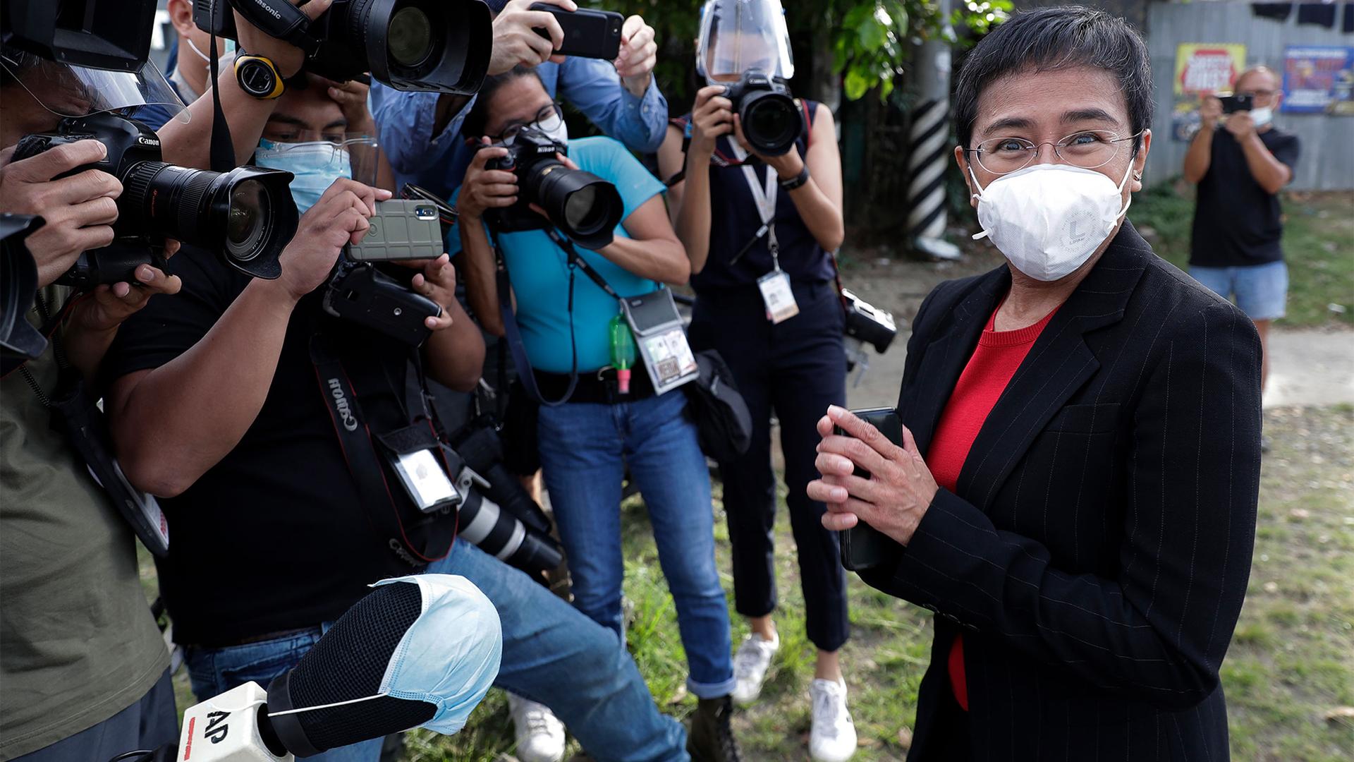 Rappler CEO and Executive Editor Maria Ressa, right, stands in front of reporters as she arrives at the Court of Tax Appeals in Metro Manila, Philippines