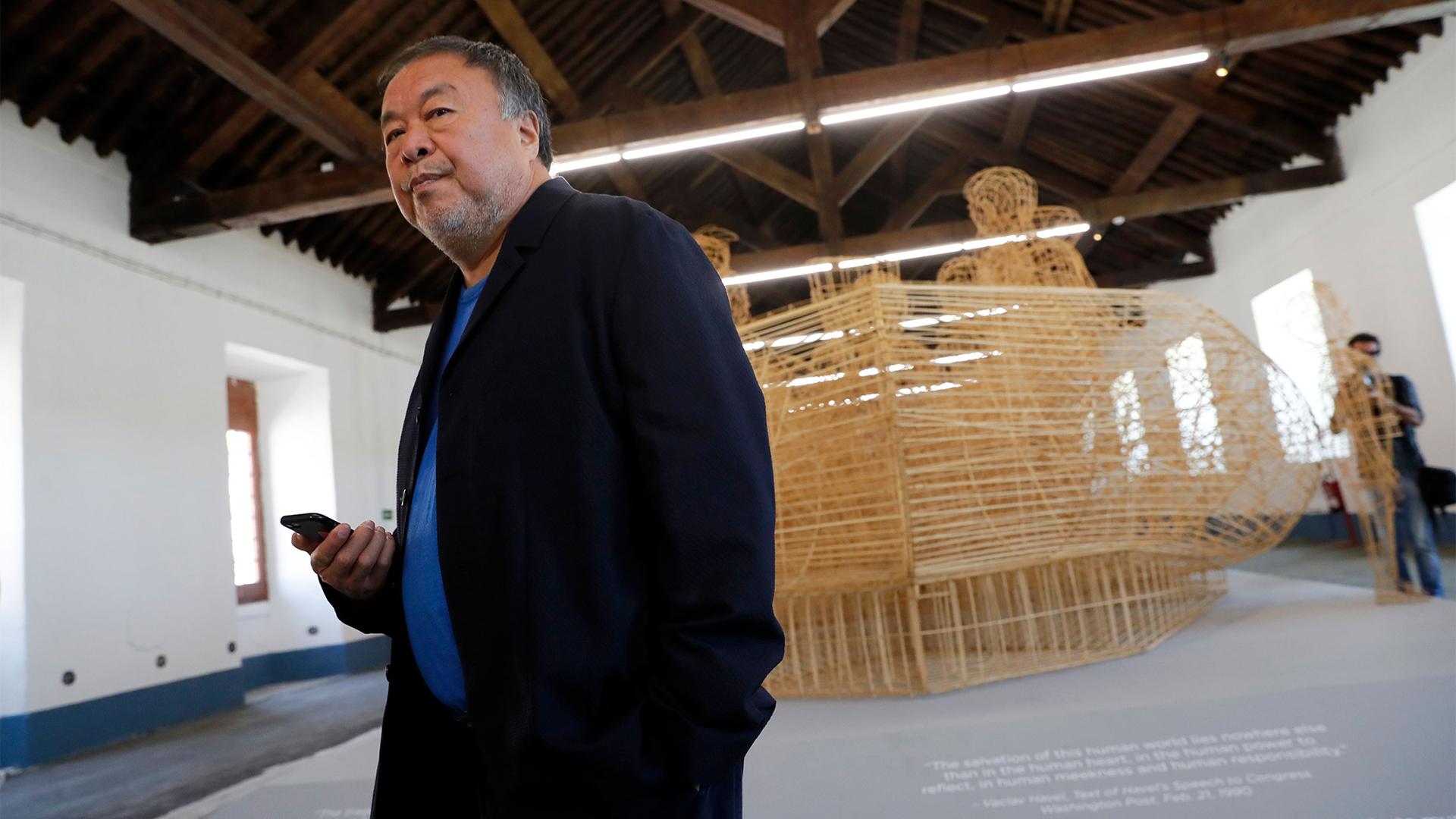 Dissident Chinese artist Ai Weiwei walks by his work 
