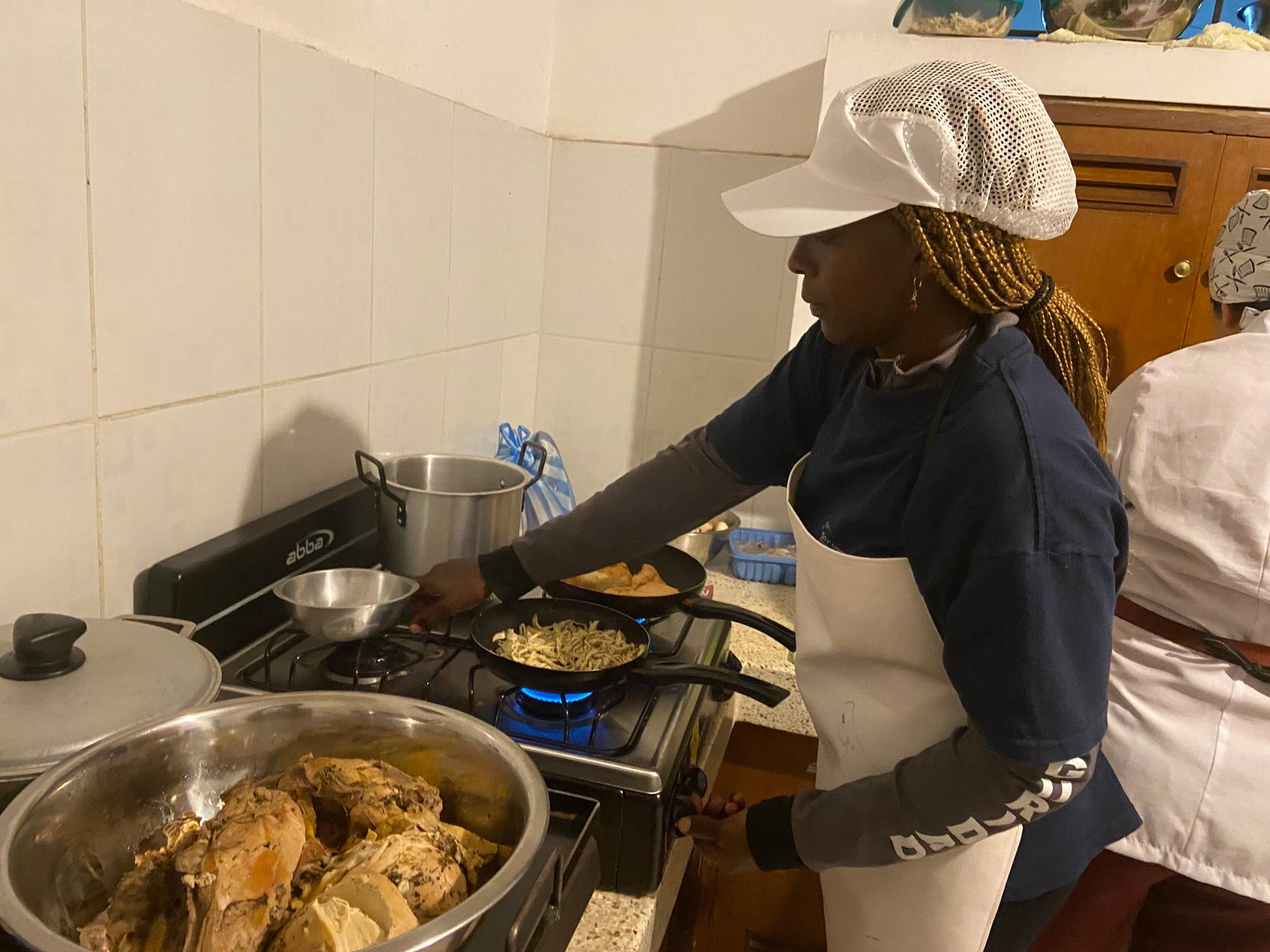 Celeni Charrupí prepares a chicken sandwich and french fries at the start of her shift in the kitchen at La Trocha, sentires de la montaña.