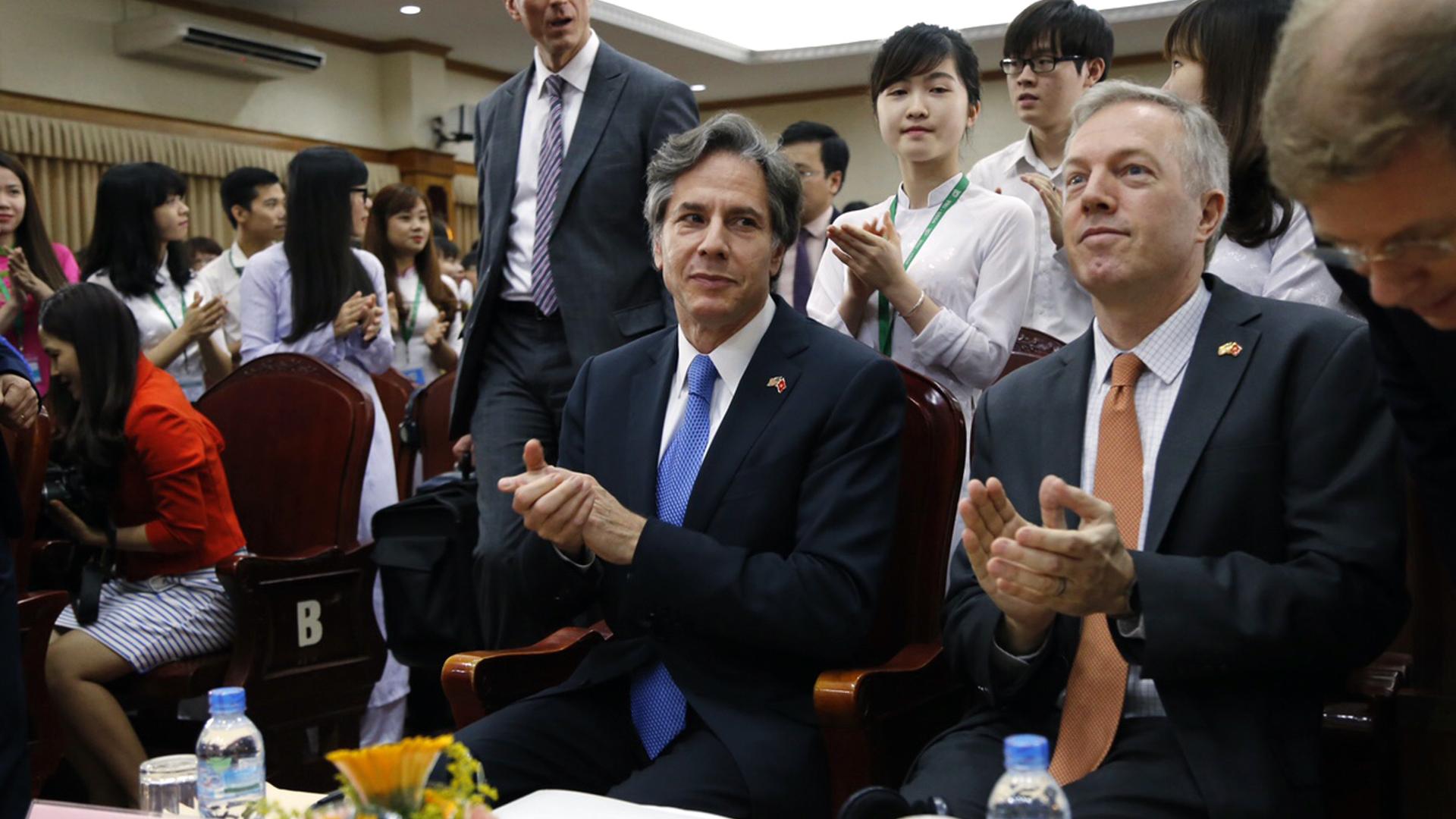 US Deputy Secretary of State Antony Blinken, center, claps with former US Ambassador to Vietnam Ted Osius, second from right, during his visit to Vietnam National University in Hanoi, Vietnam, April, 21, 2016. 