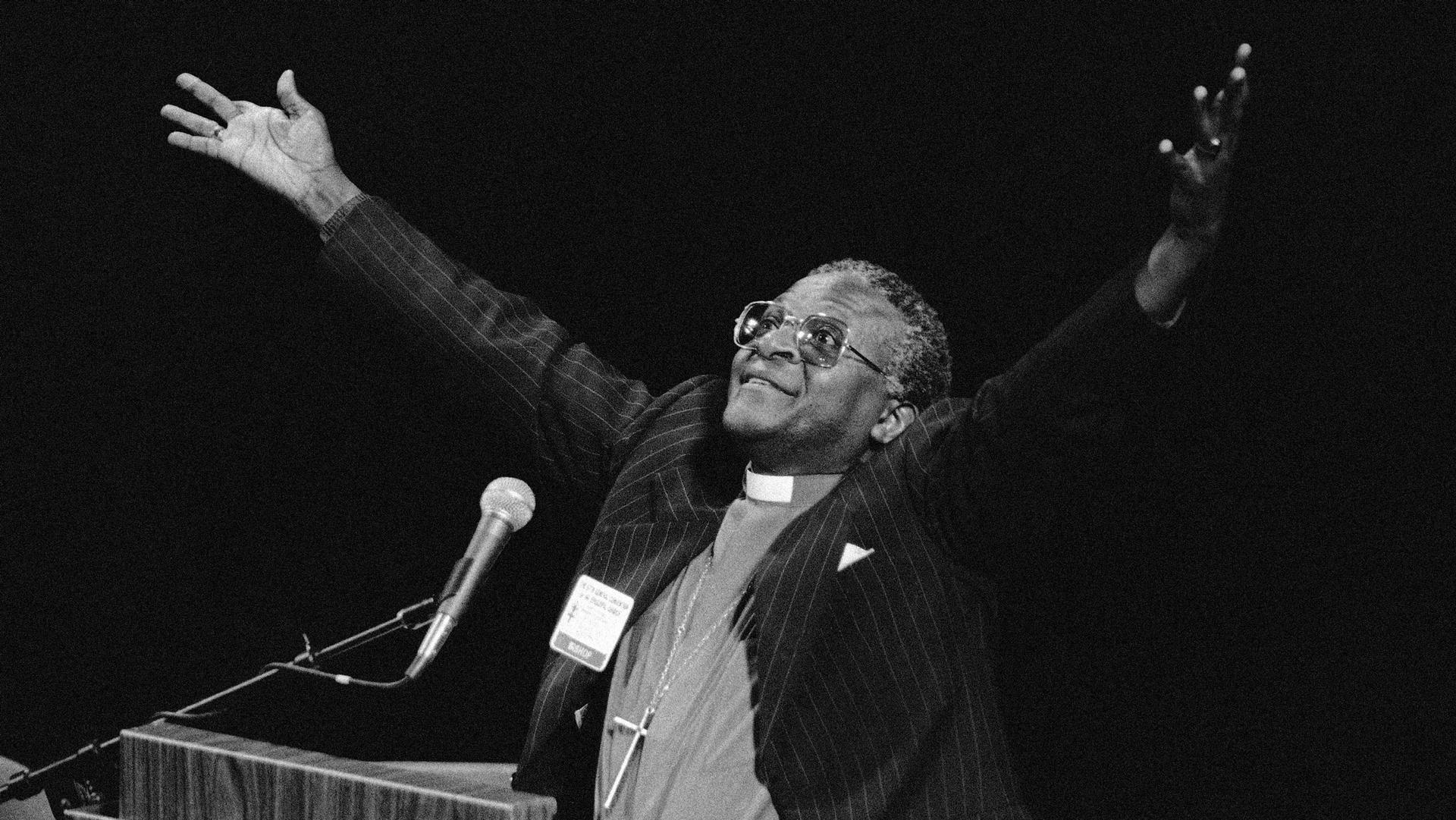 South African Bishop Desmond Tutu gestures during remarks denouncing his country's apartheid policy of racial separation in New Orleans, Sept. 7, 1982. 